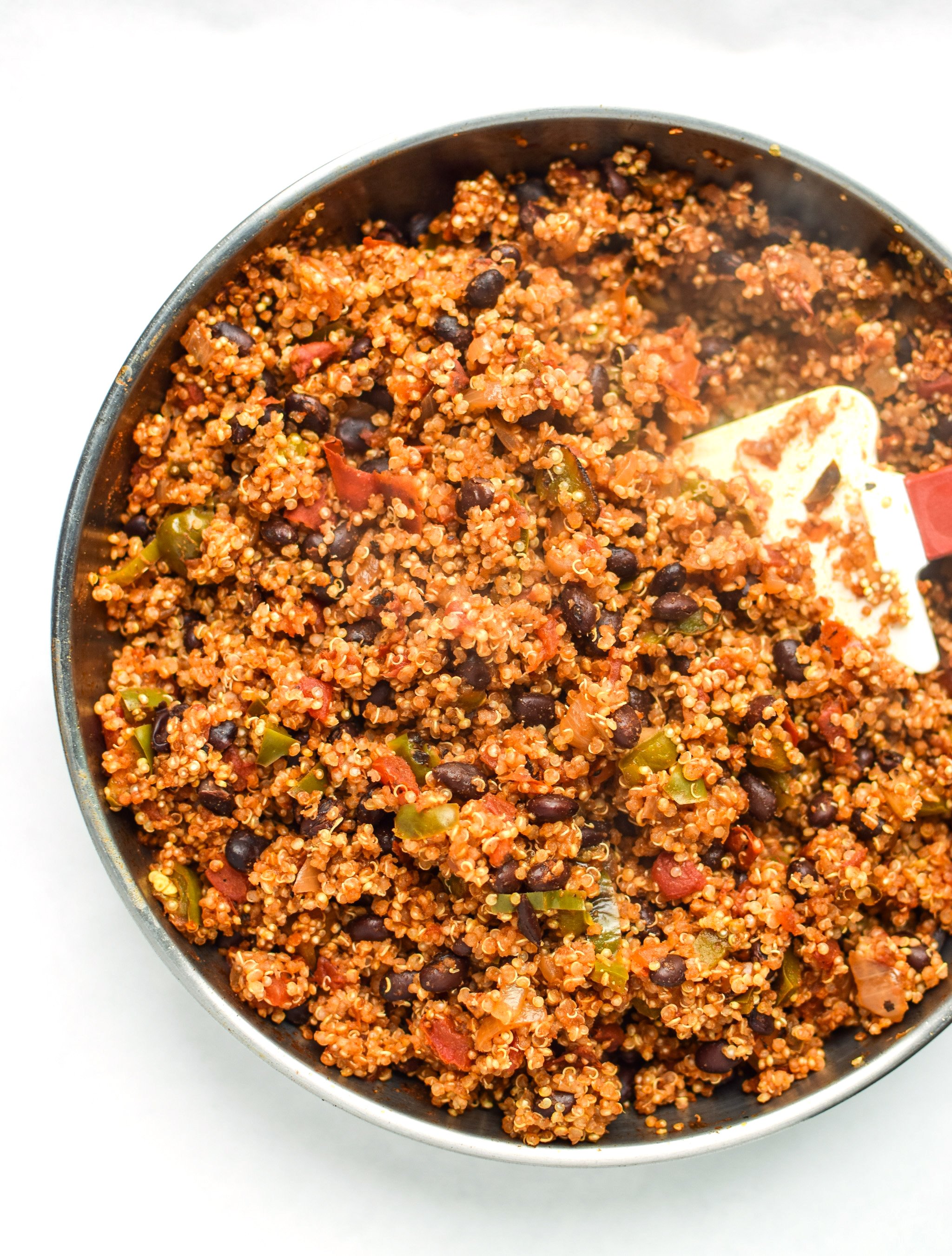An overhead view of a skillet of cooked mexican quinoa with fire roasted tomatoes, peppers and onions.