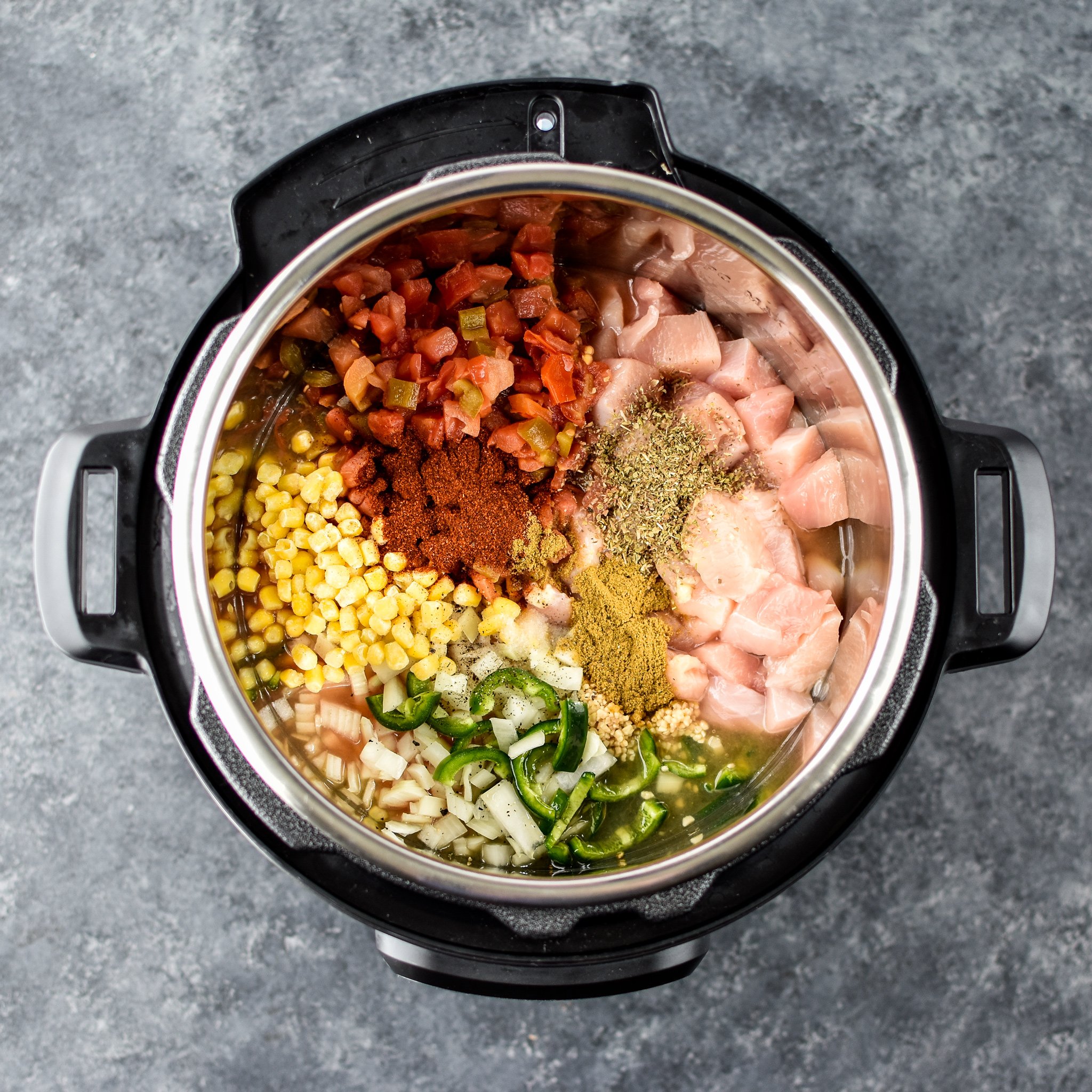 A view of the ingredients for the Instant Pot Jalapeno Popper chicken Soup inside the Instant Pot from above.