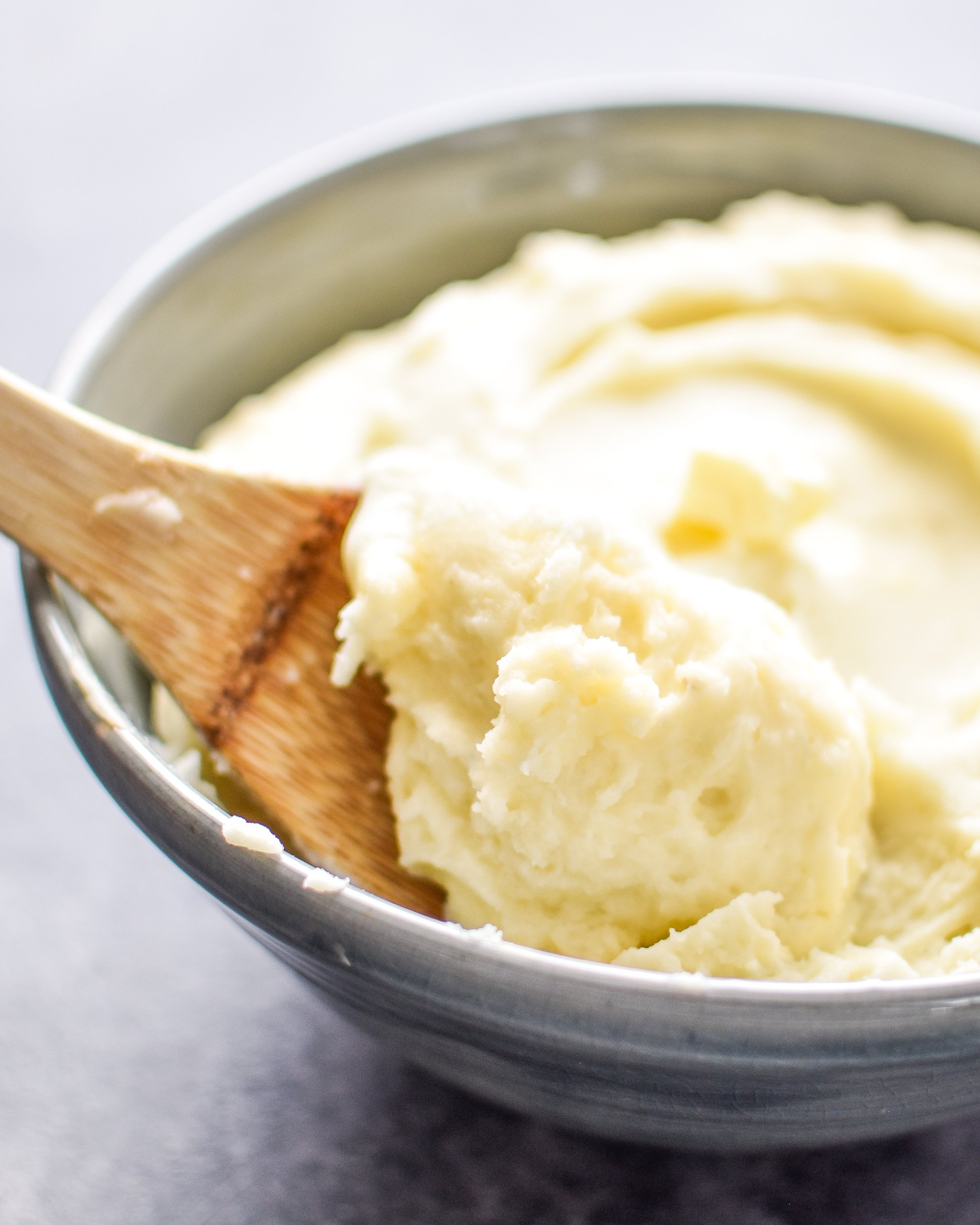 A spoonful of 3-Ingredient Mashed Potatoes resting in a dish of mashed potatoes.