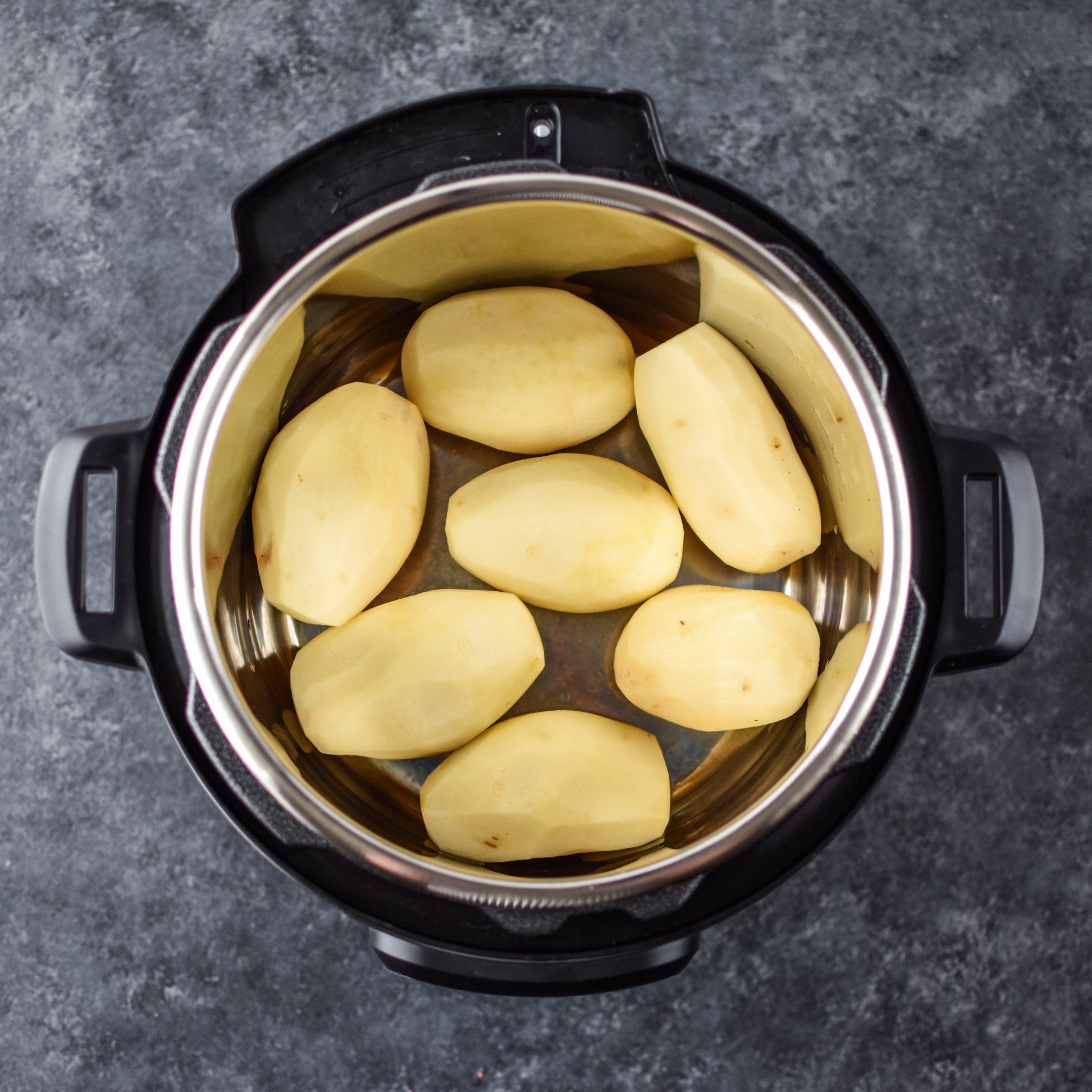 7 russet potatoes peeled in an Instant Pot ready to be cooked.