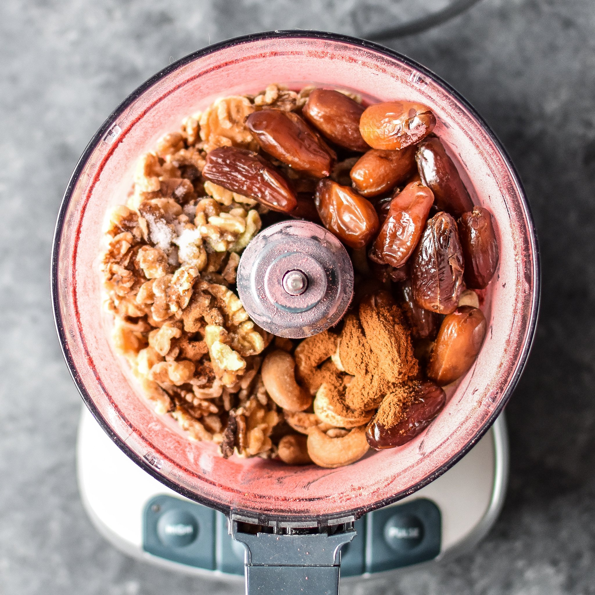 A food processor bowl full of the ingredients to make Spiced Berry Bliss Balls.