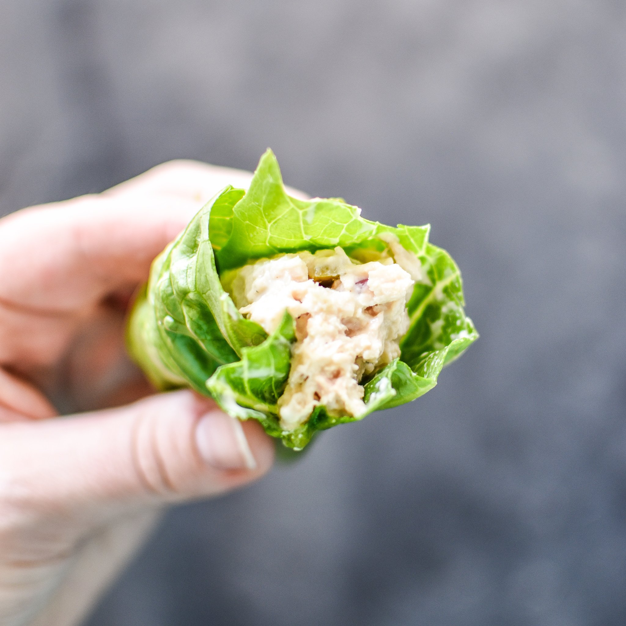 Holding a tuna salad lettuce wrap meal prep item in hand.