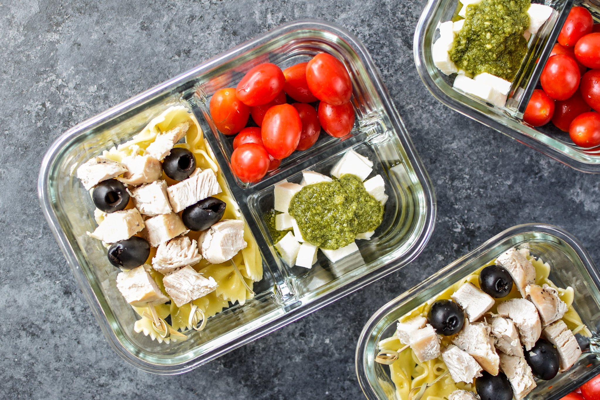 A view of the DIY Chicken Pesto Pasta Skewers Meal Prep from above, including grape tomatoes, fresh mozzarella and traditional pesto!
