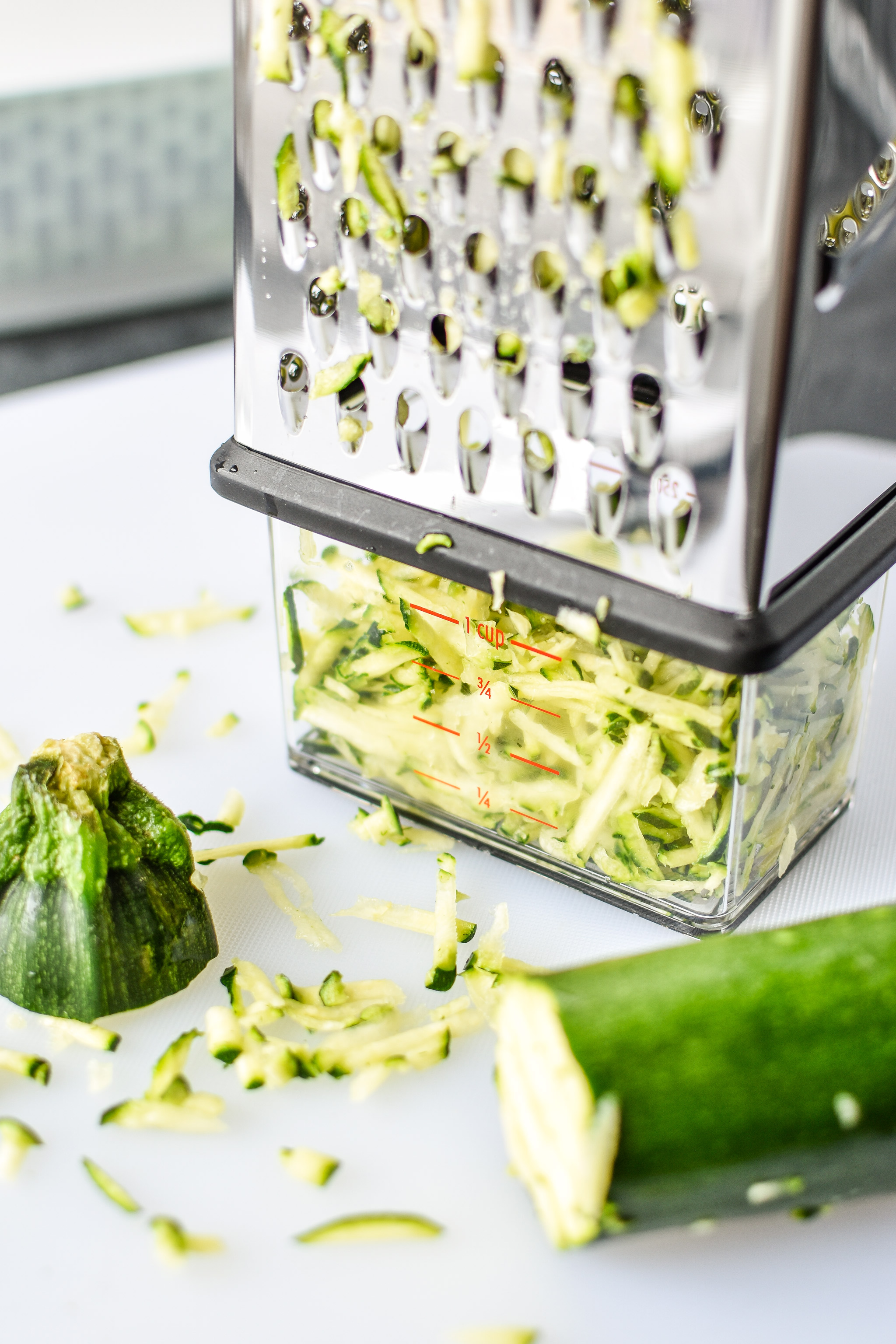 Grating zucchini using an OXO grater for the Blackberry Bran Muffins.