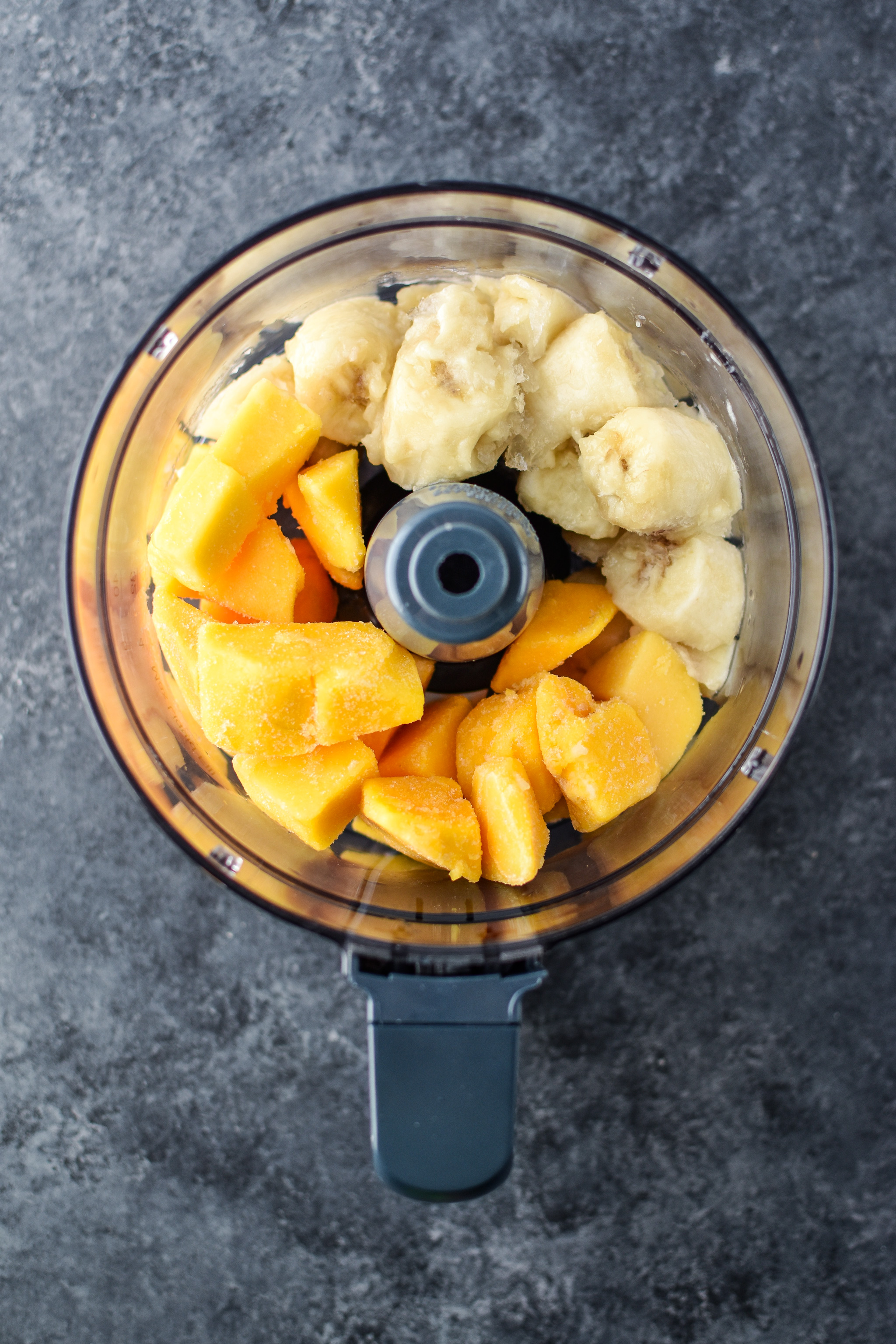 Above view of the ingredients in the food processor to make Mango Lime Nice Cream.