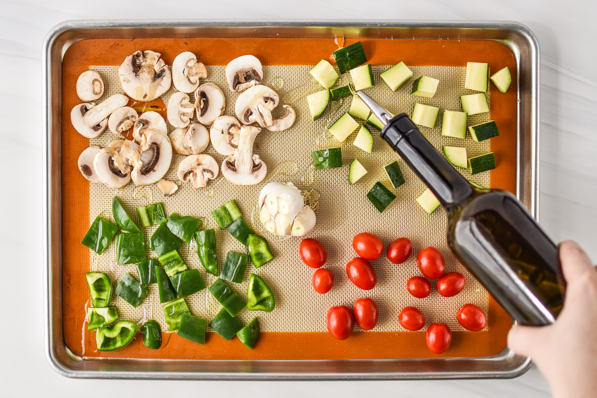 Adding oil to the veggies for the chicken meatballs two ways meal prep lunches