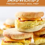 meal prep make ahead bacon breakfast sandwiches stacked on a cutting board.