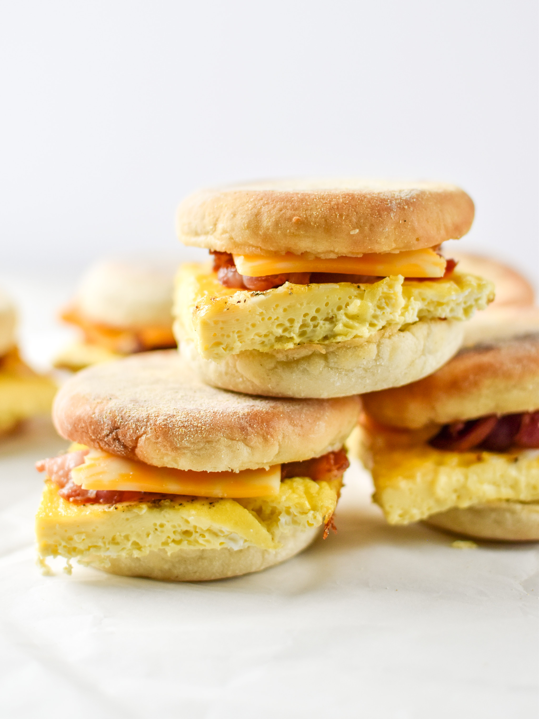 A stack of make-ahead bacon breakfast sandwiches with egg cheese and bacon.