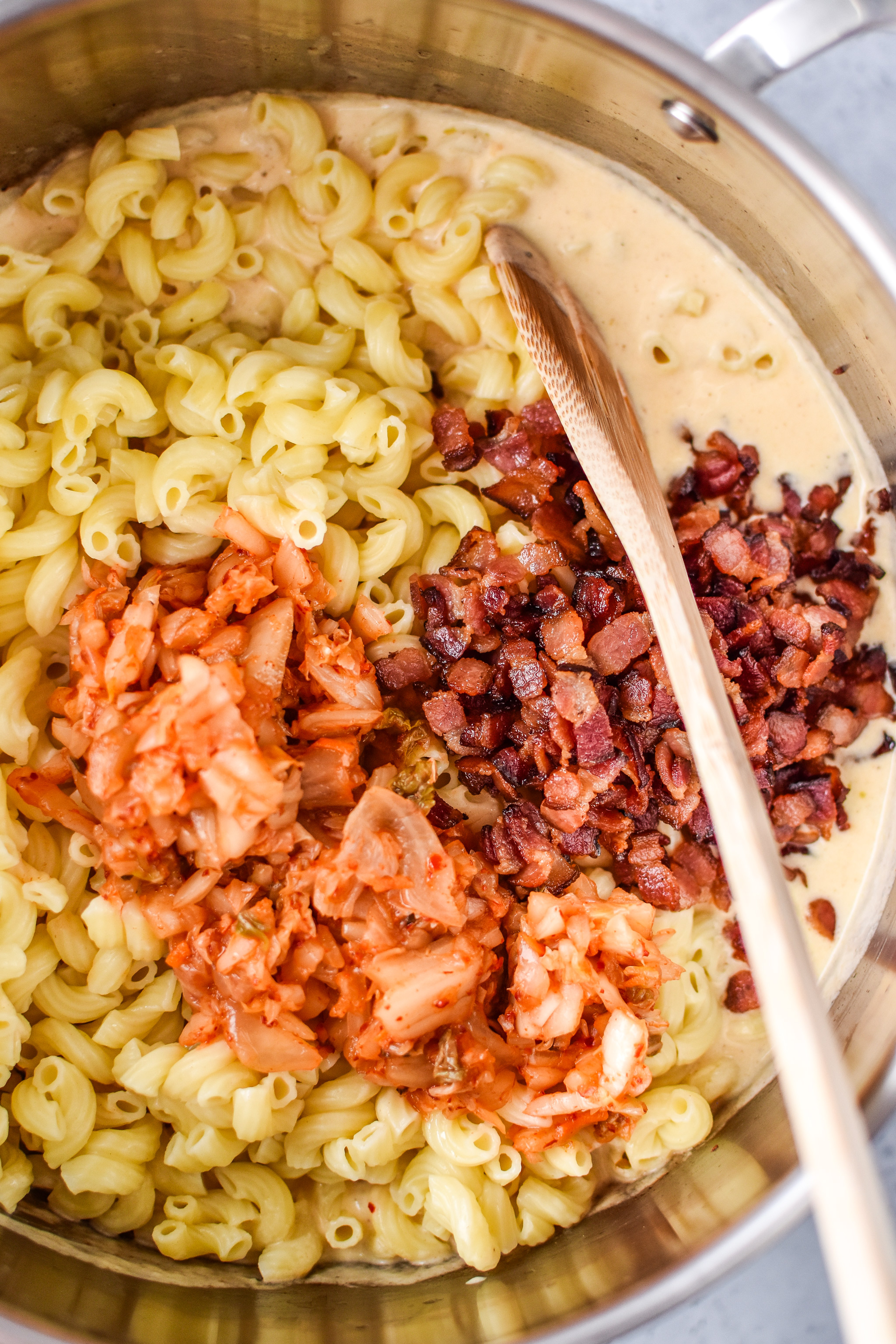 ingredients being mixed together to make the kimchi bacon greek yogurt mac and cheese