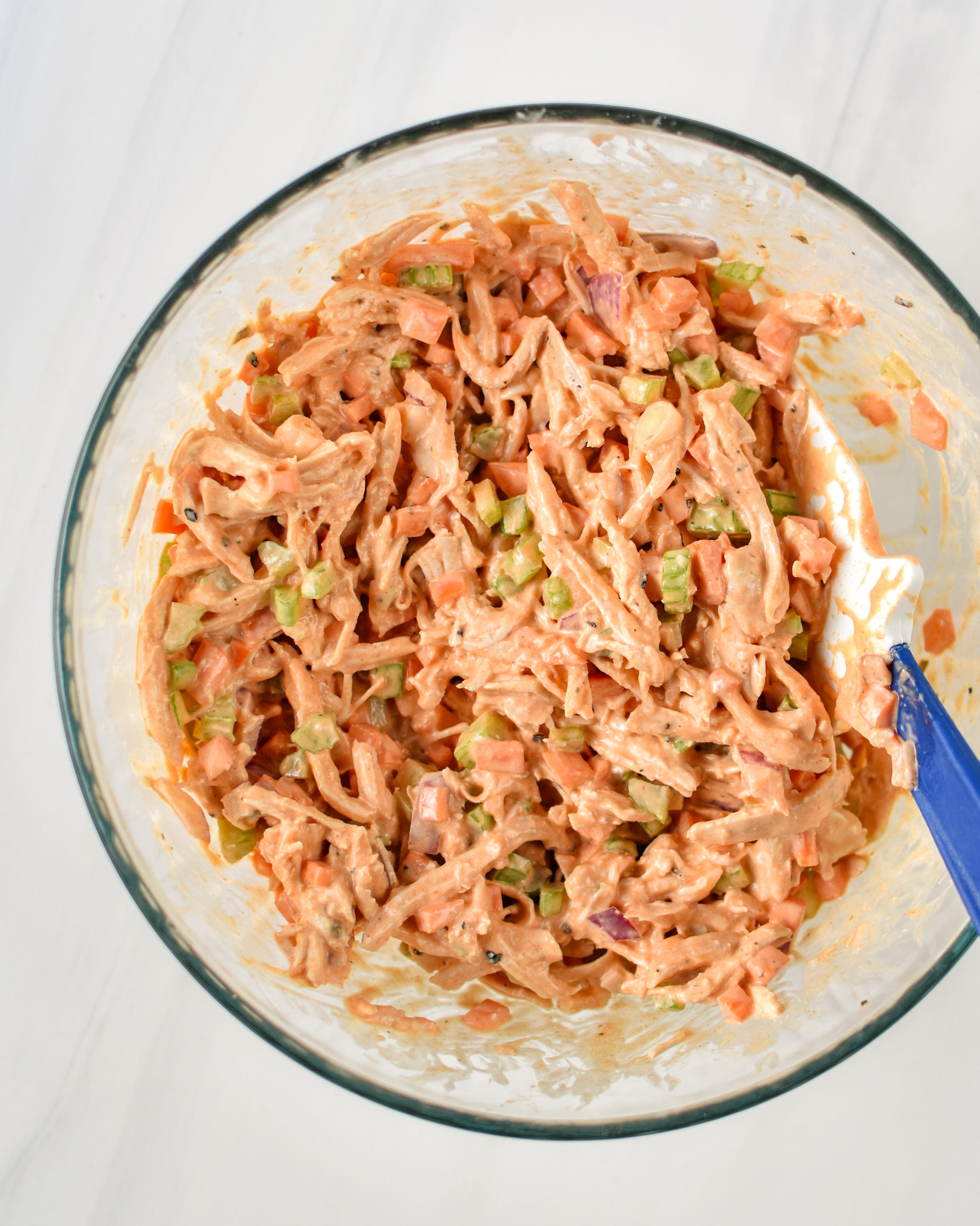 Buffalo chicken salad mixed up in a large pyrex dish.