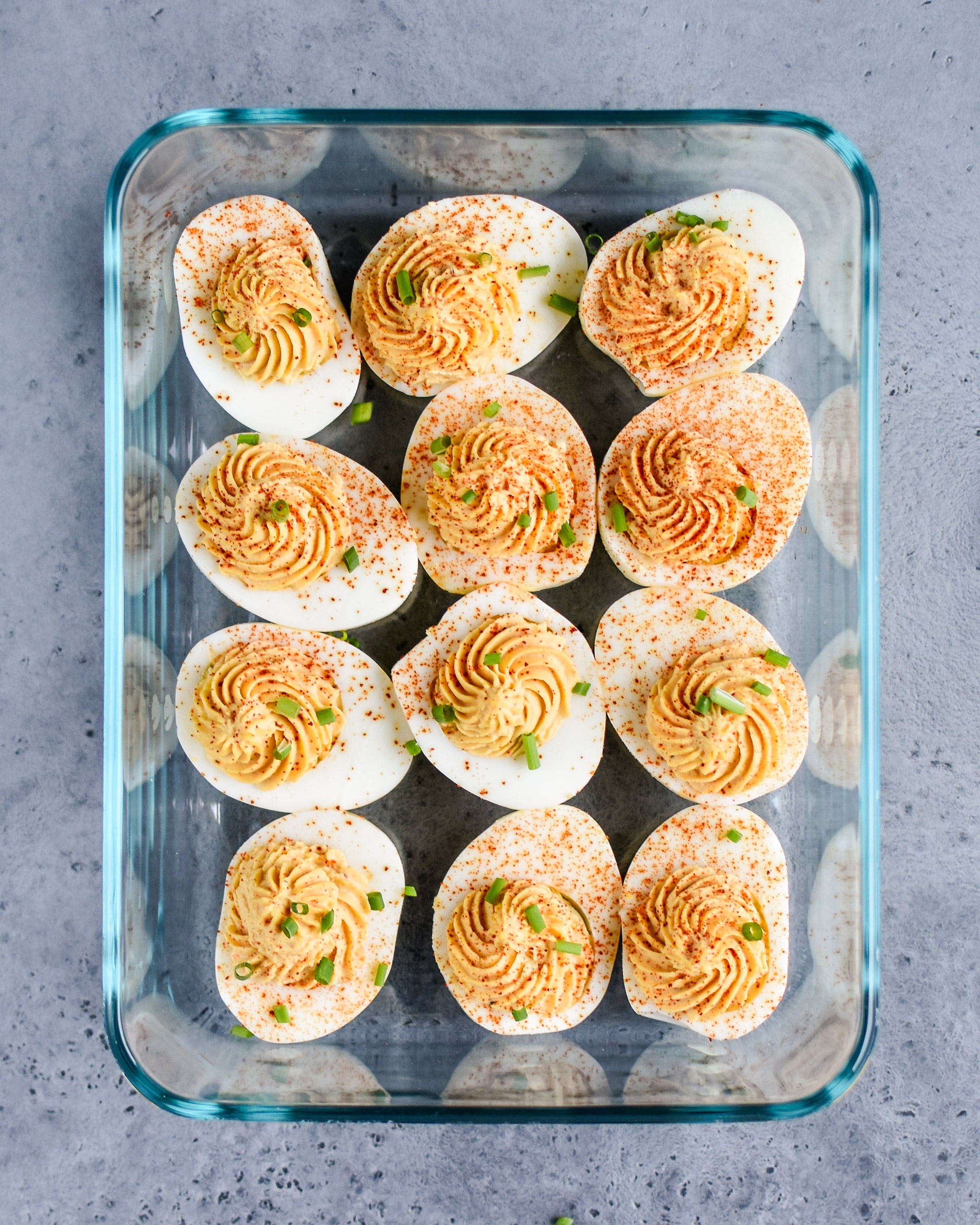 Buffalo deviled eggs stored in a rectangular pyrex container.