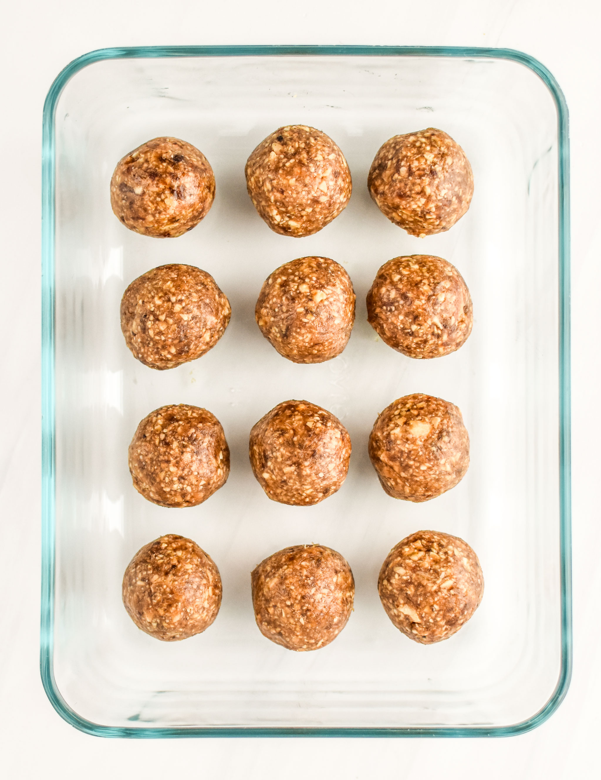 Peanut butter cookie balls stashed in a Pyrex container for storage.