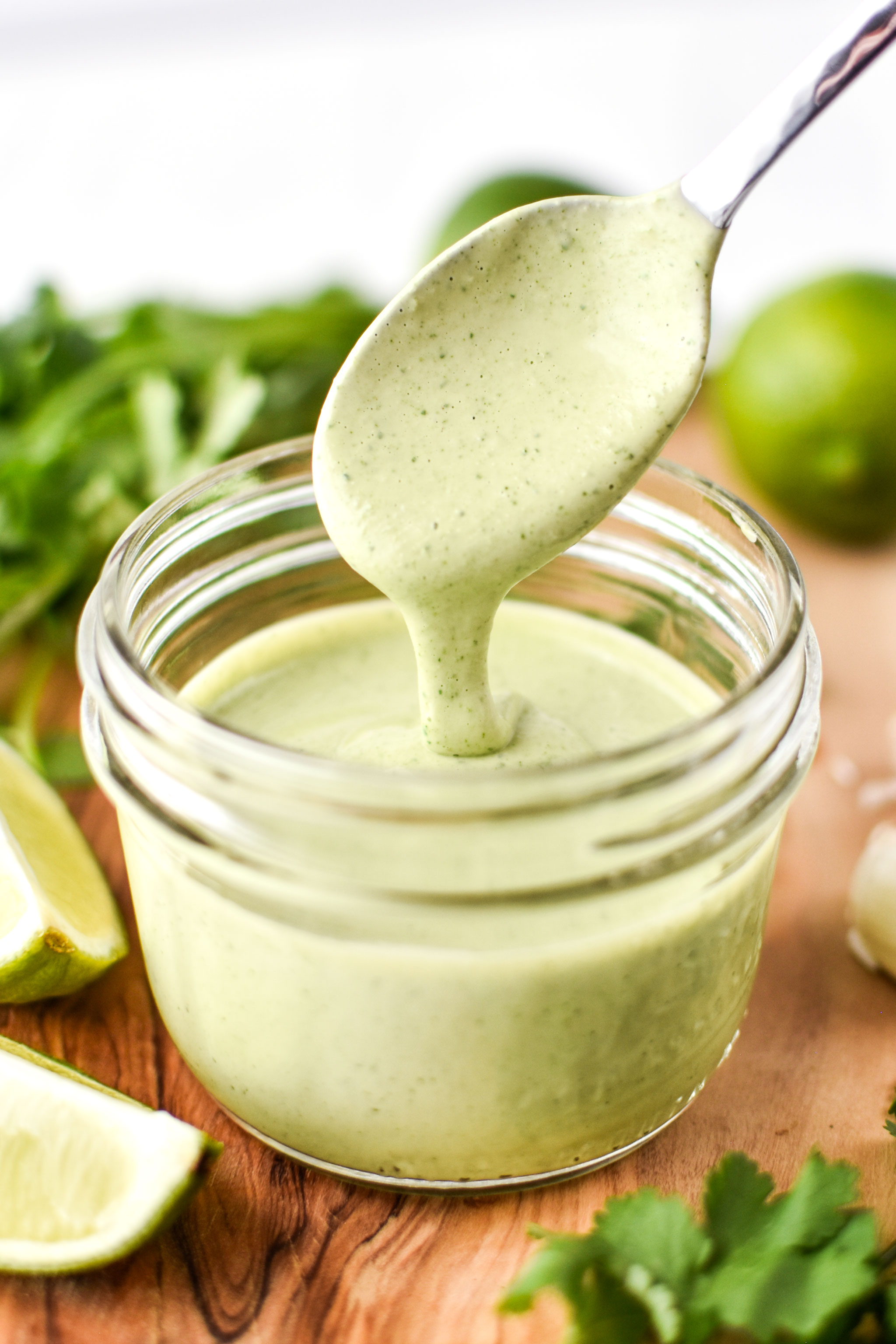 Fresh made cilantro lime tahini dressing drizzling off a spoon