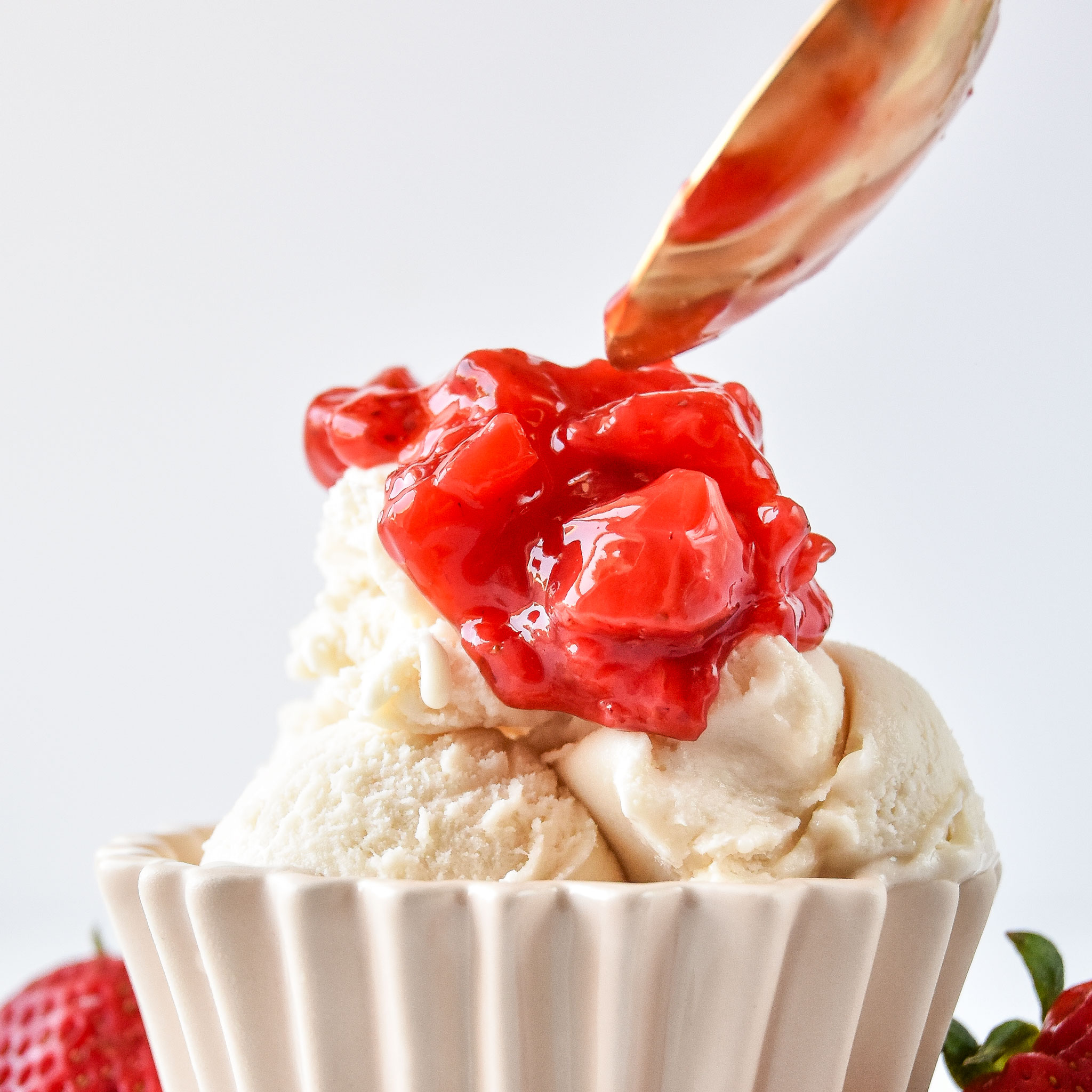 Spooning some easy strawberry sauce on ice cream