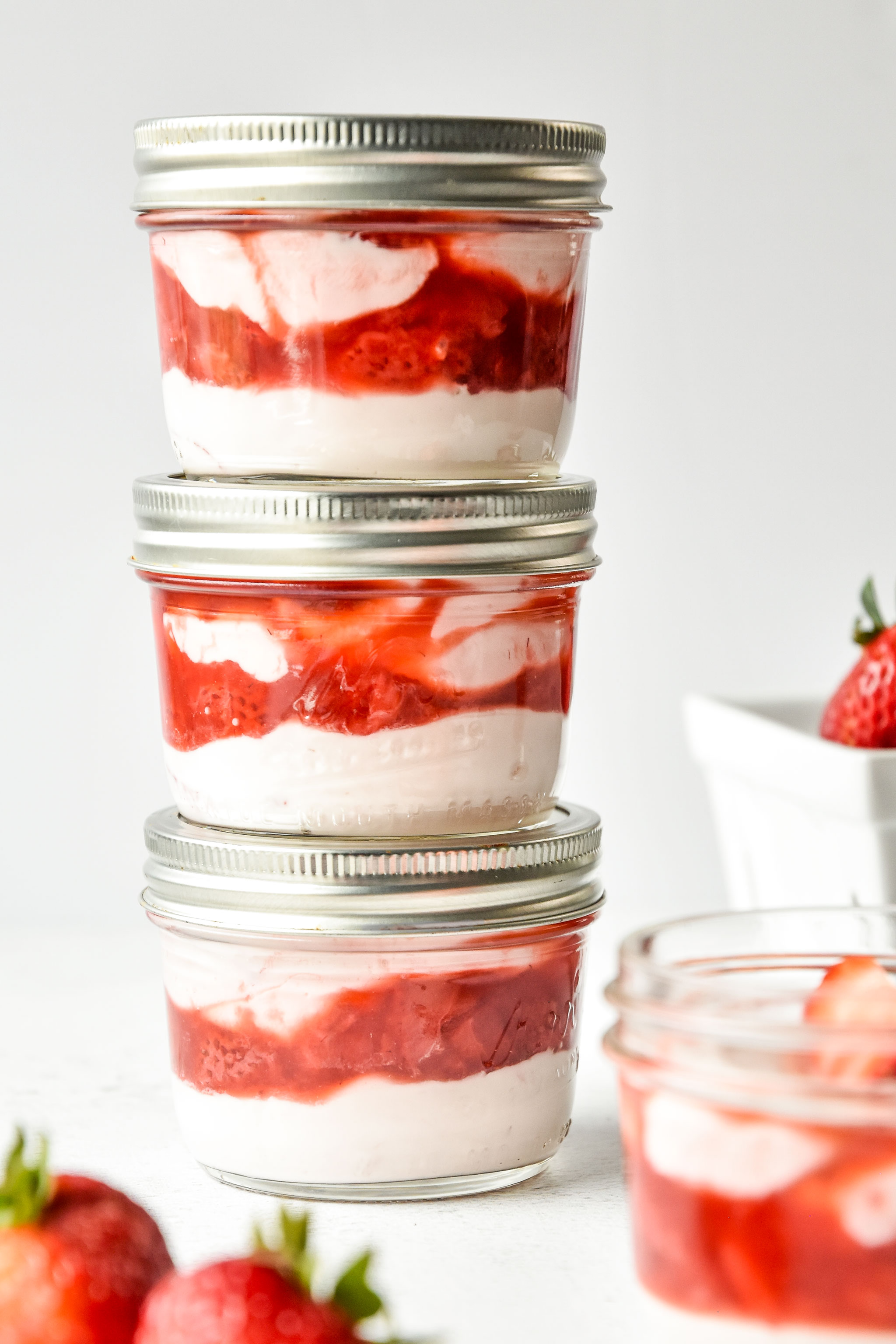 Strawberry whipped yogurt cups in mason jars stacked on top of each other 