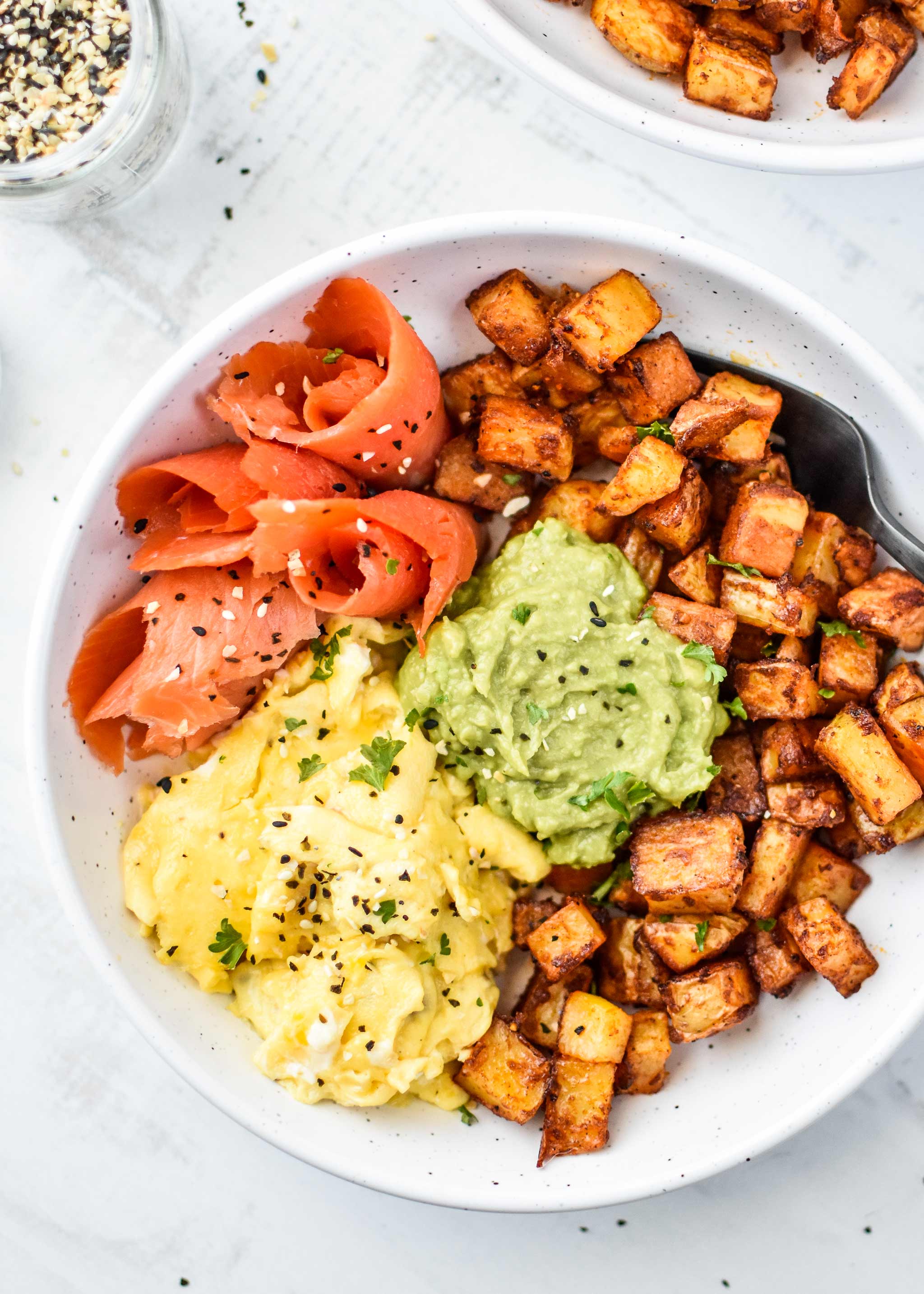 basic oven breakfast potatoes in a bowl with eggs, avocado and smoked salmon