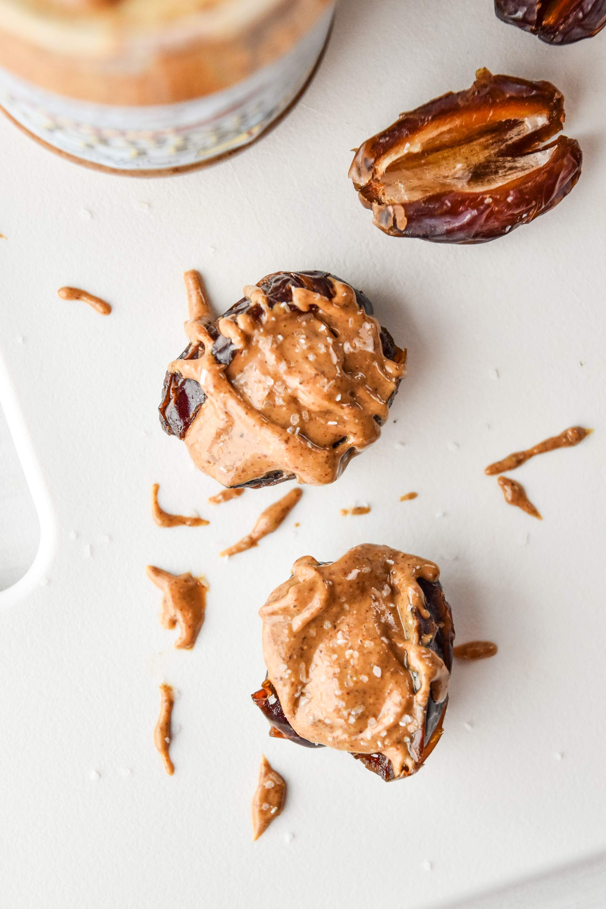 salted almond butter stuffed dates on a cutting board