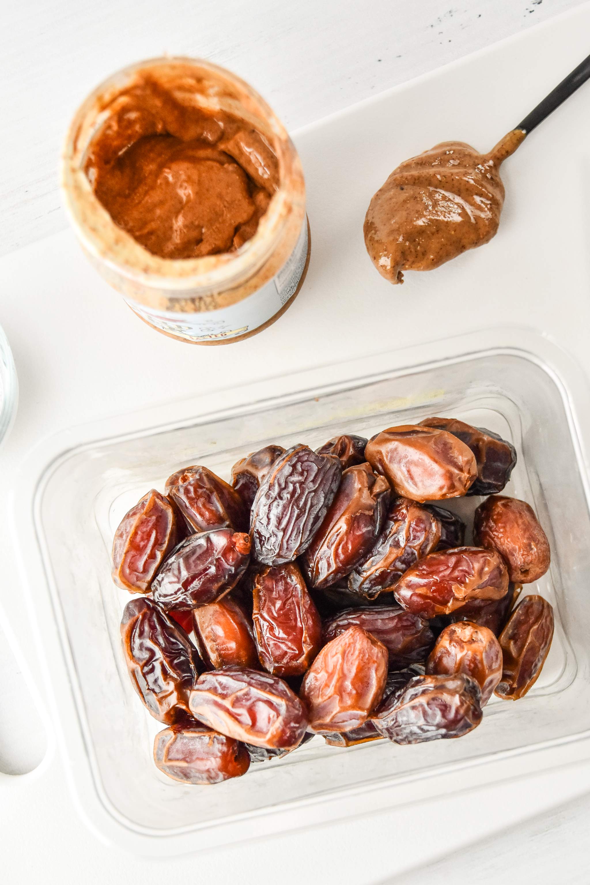 medjool dates and some almond butter on a cutting board
