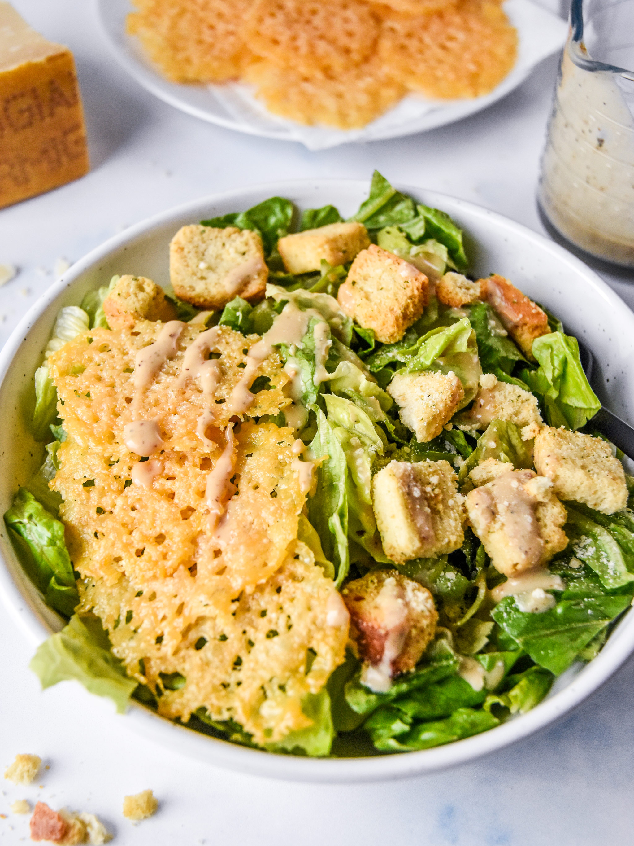 baked parmesan crisps on a caesar salad