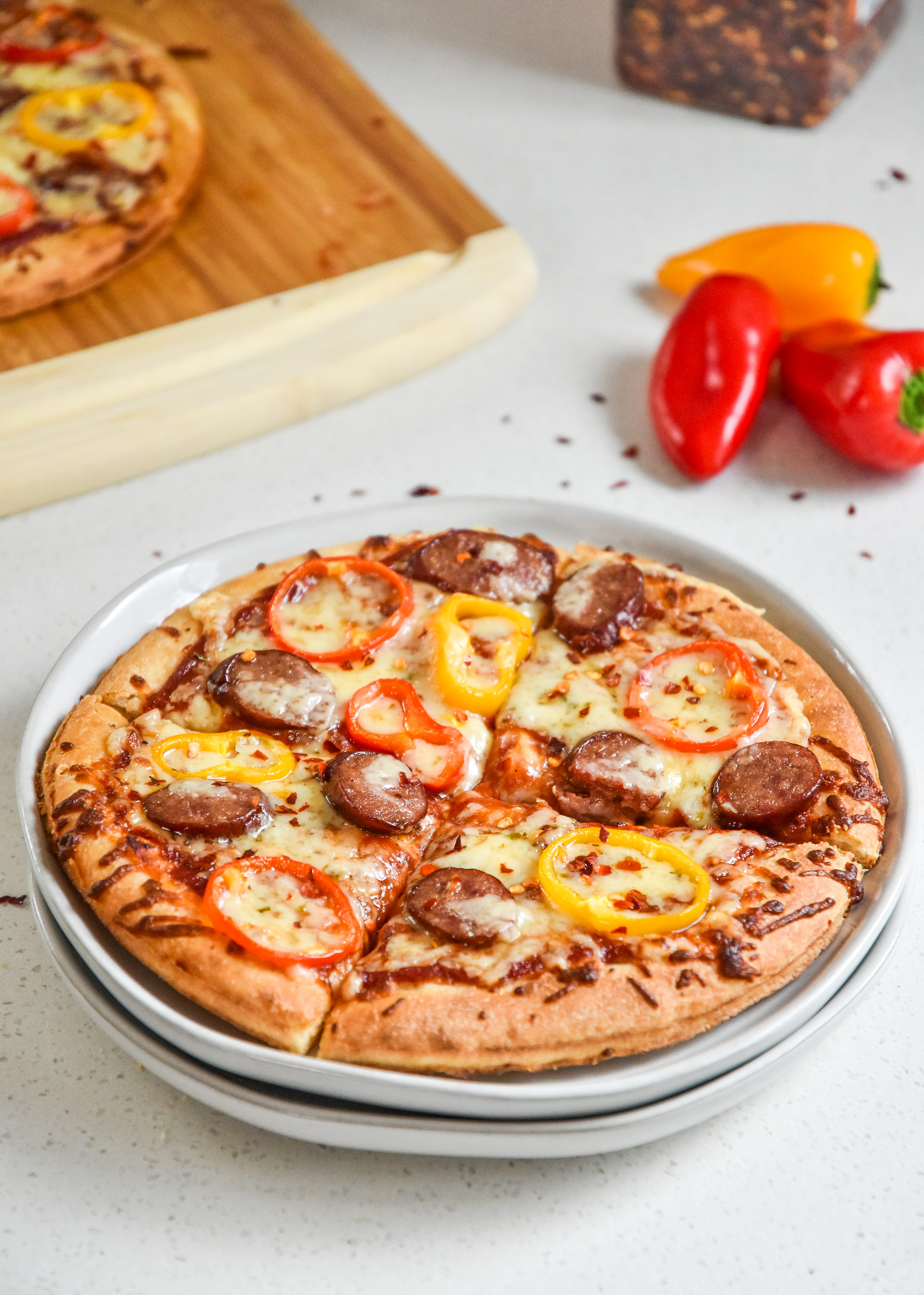 sausage and pepper personal pizzas served on a plate
