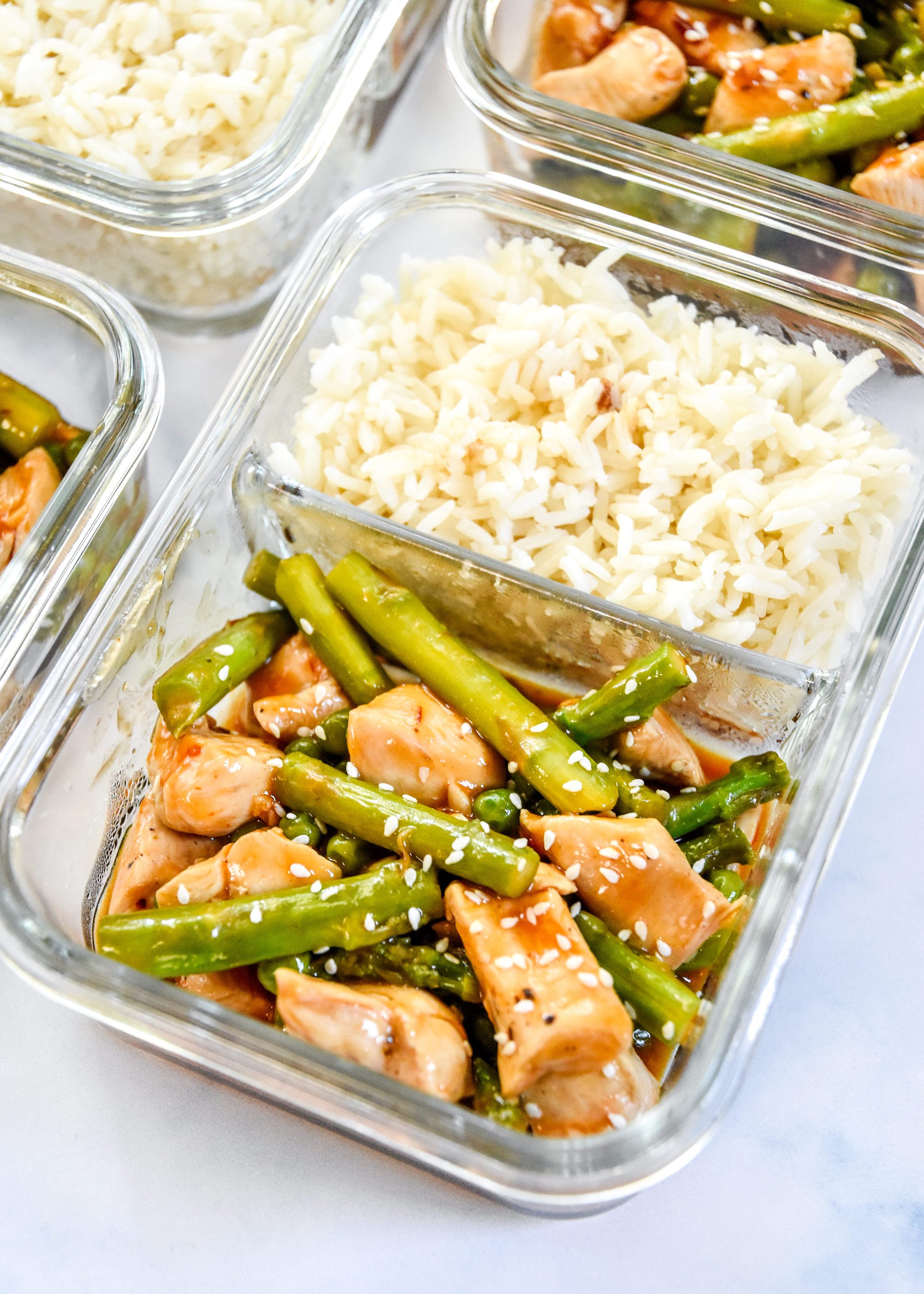 meal prep spicy chicken asparagus meal with rice in a glass meal prep container