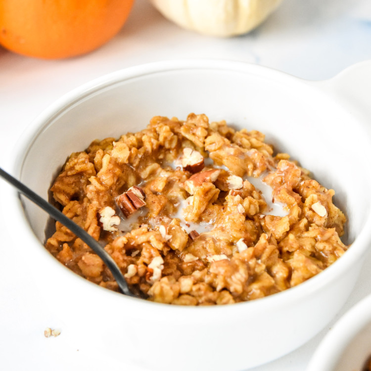 bowl of oatmeal with pecans on top.