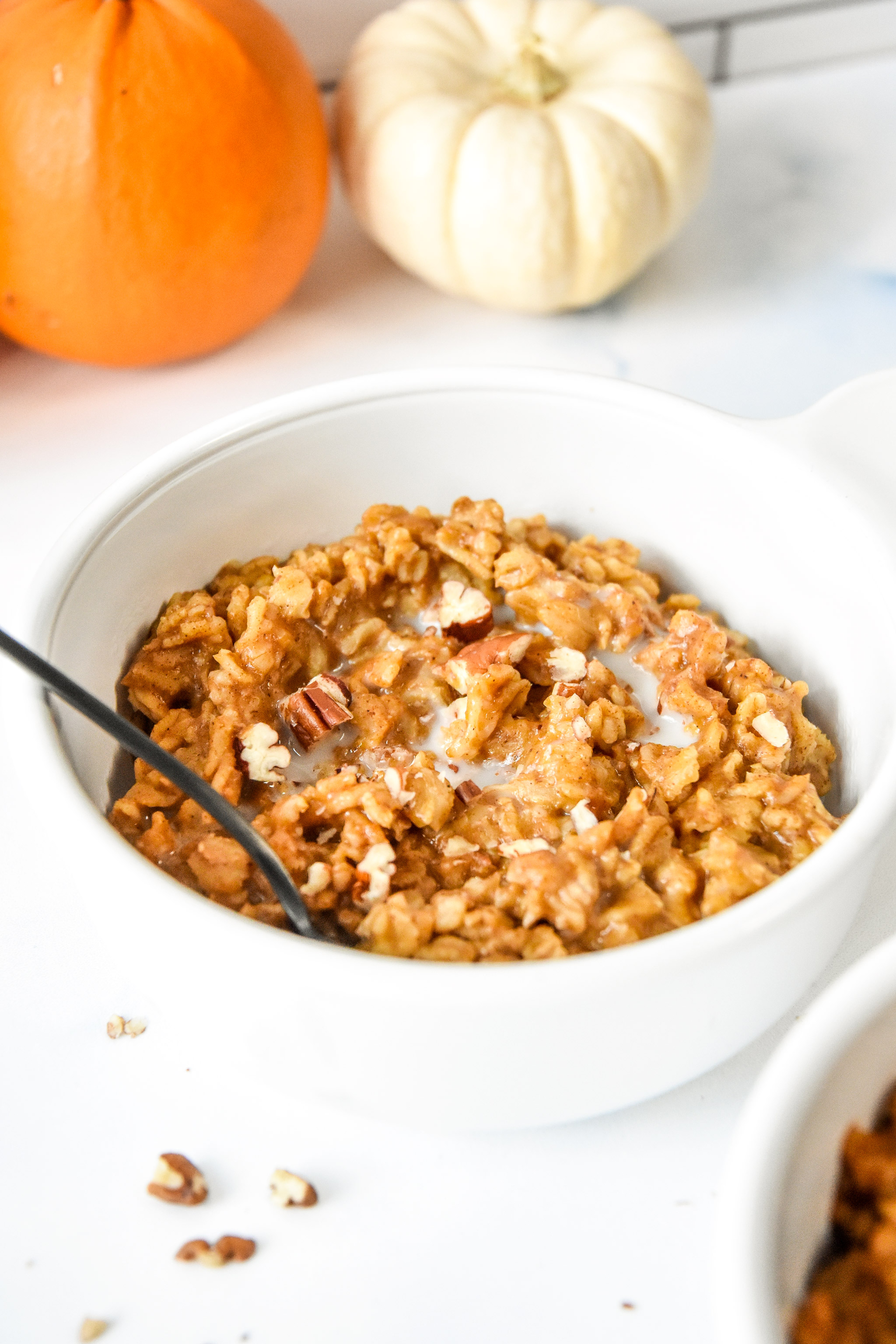 bowl of oatmeal with pecans on top.