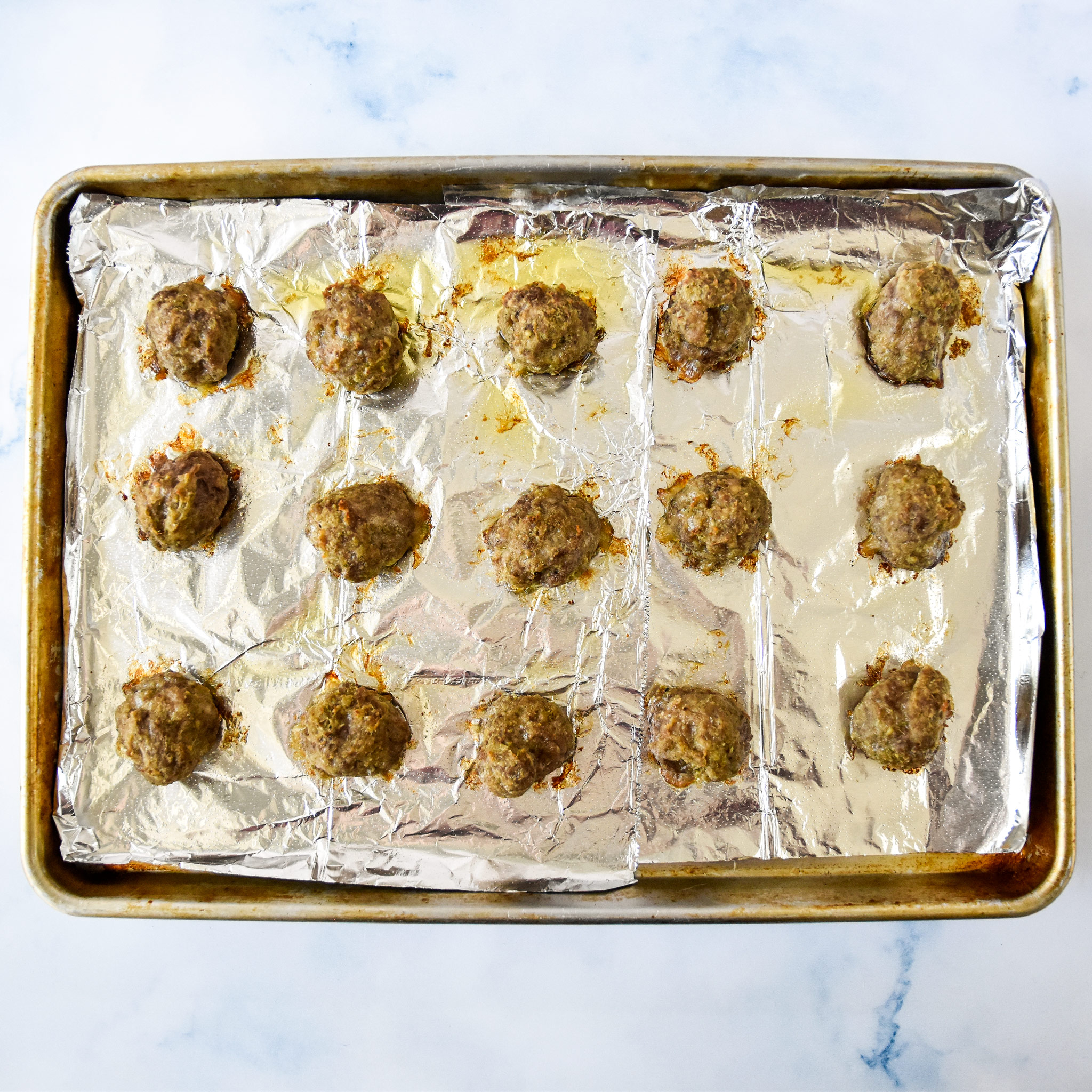 fresh baked easy freezer friendly meatballs on a sheet pan.
