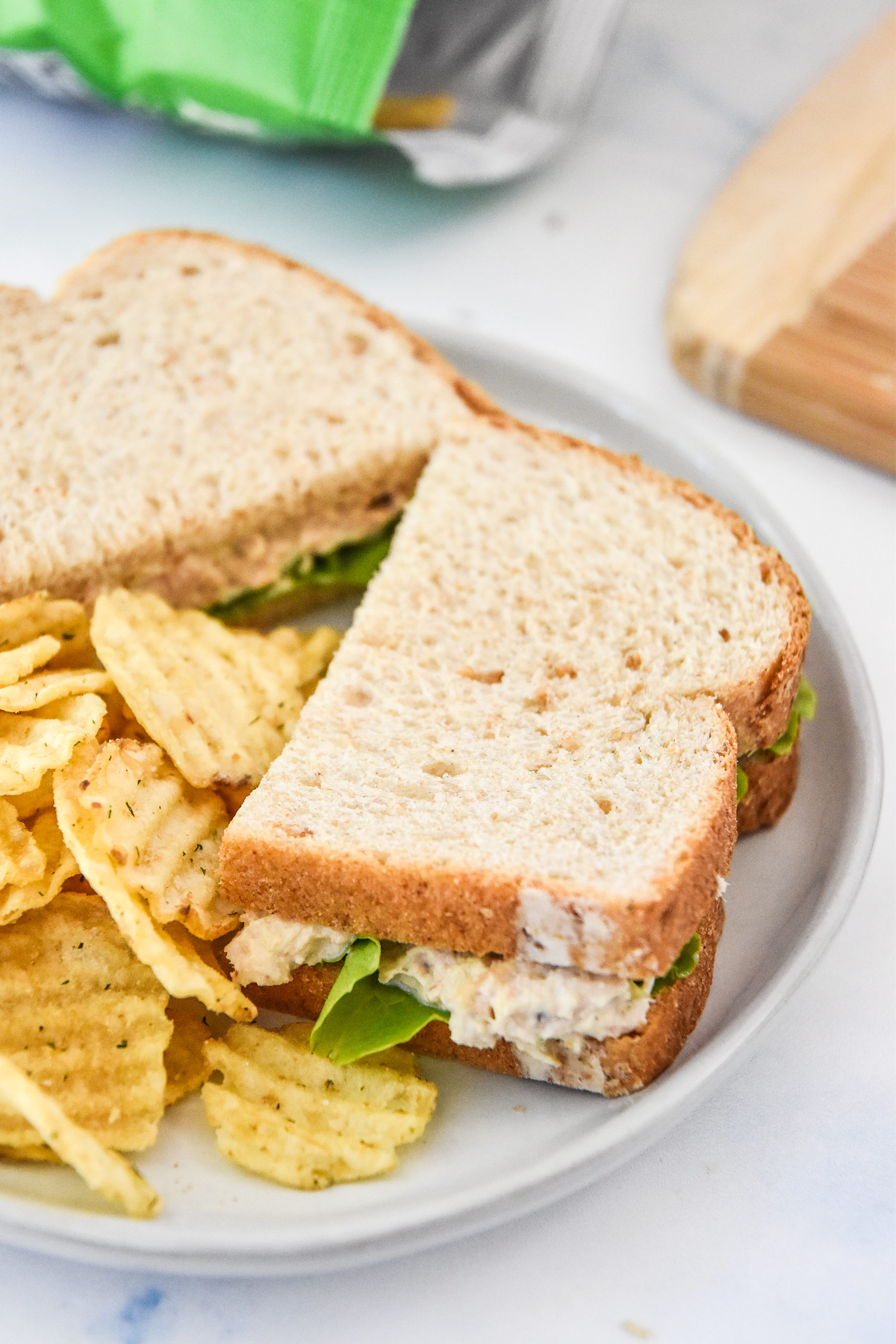 tuna salad sandwich with chips on a plate.