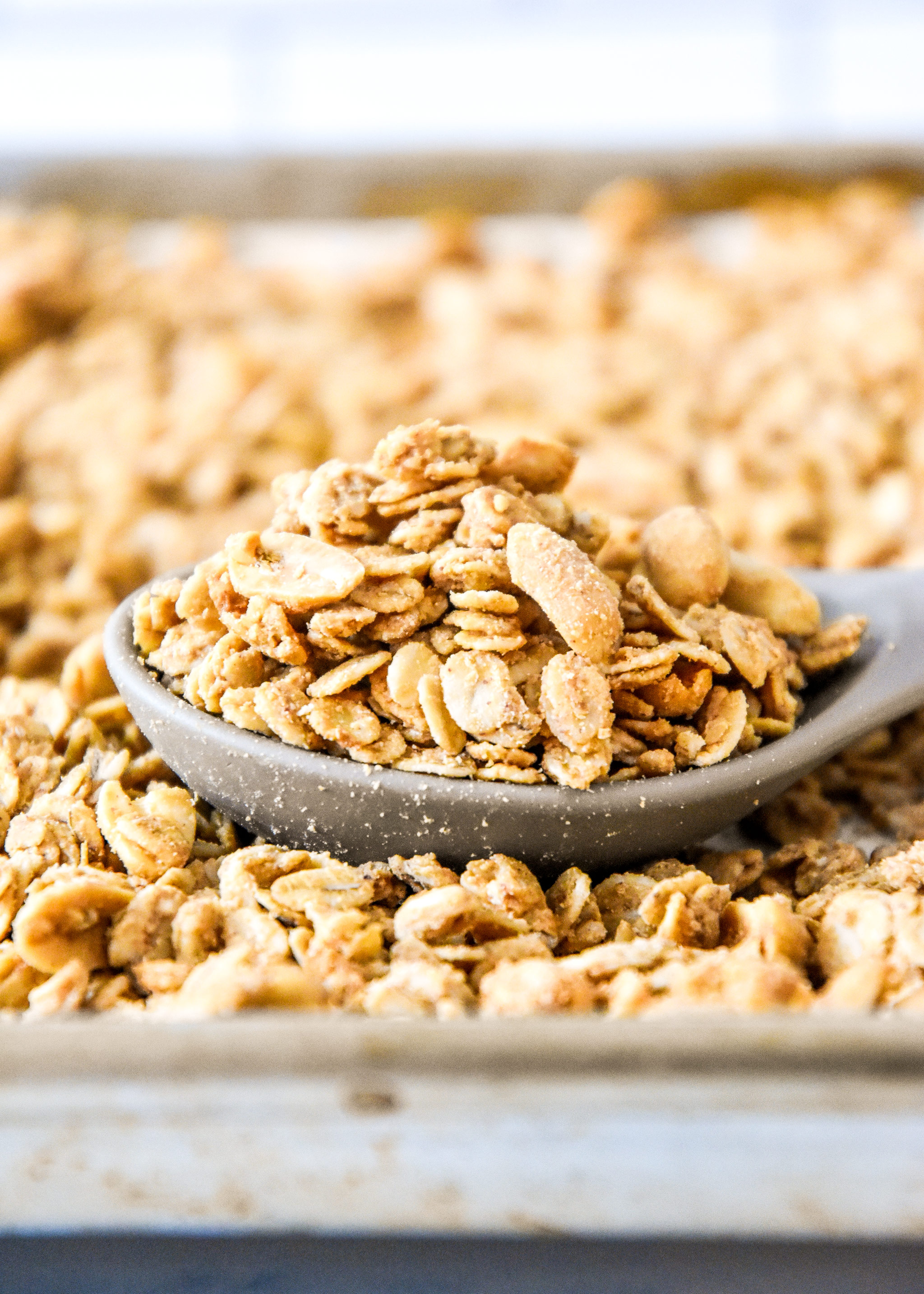 spoonful of peanut butter granola on a sheet pan.