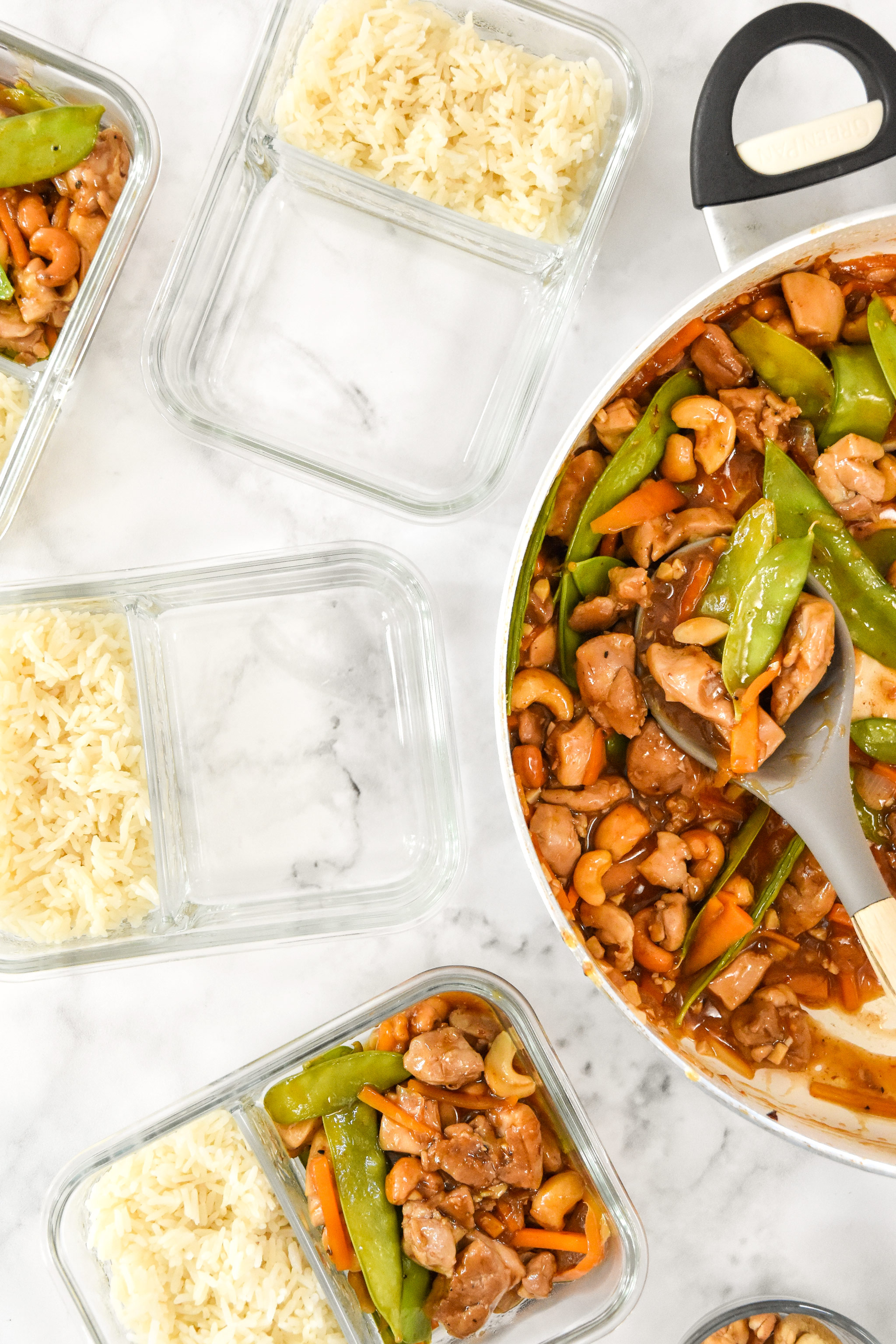 serving the cashew chicken into glass meal prep containers.