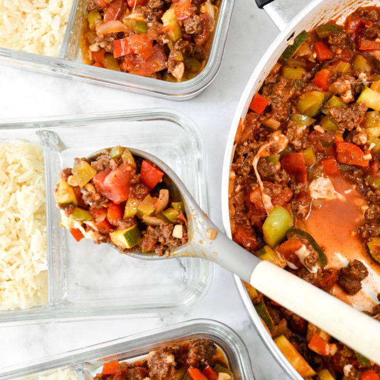 spooning unstuffed pepper mixture into the glass meal prep containers.