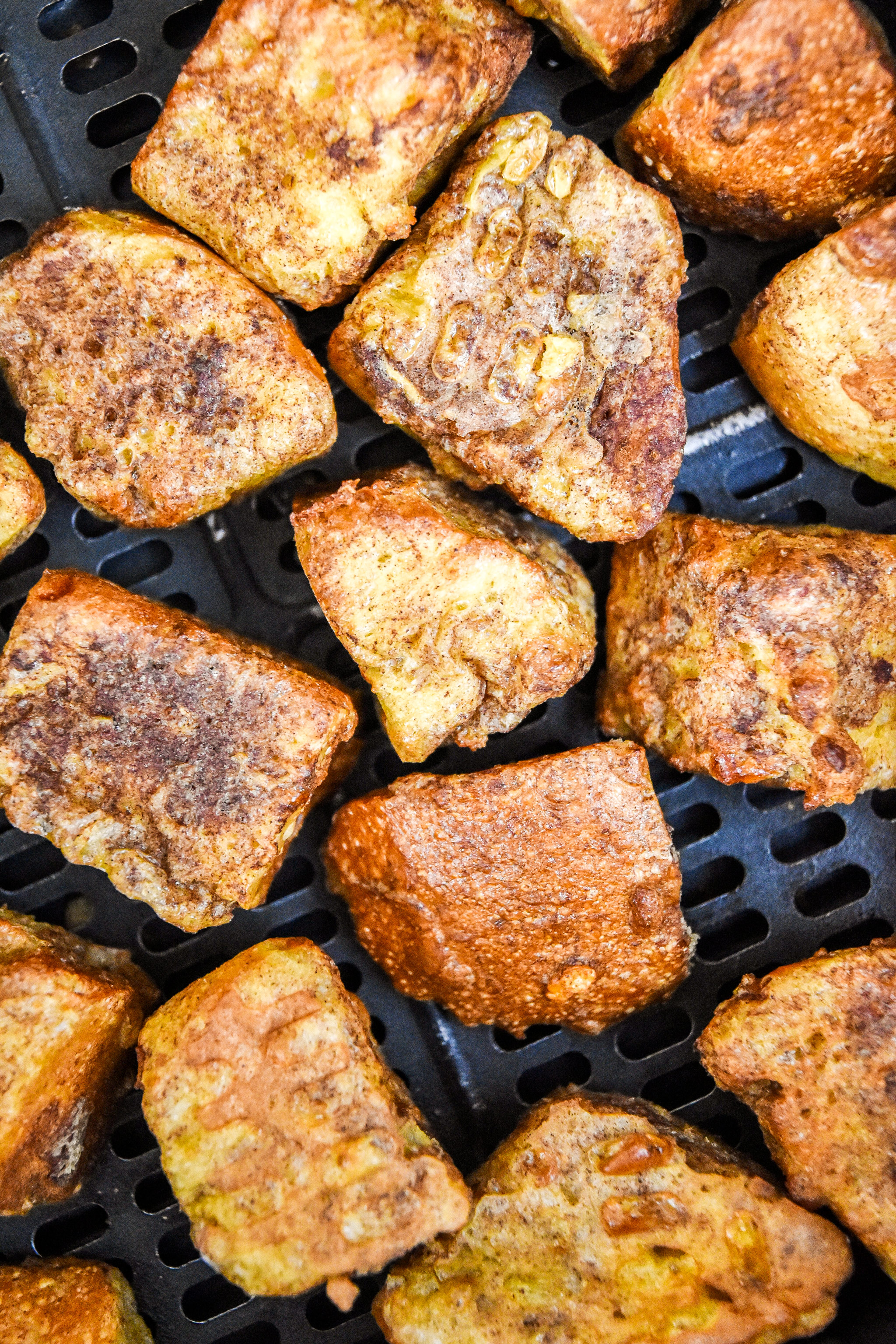 close up of air fryer french toast bites cooked in the basket.