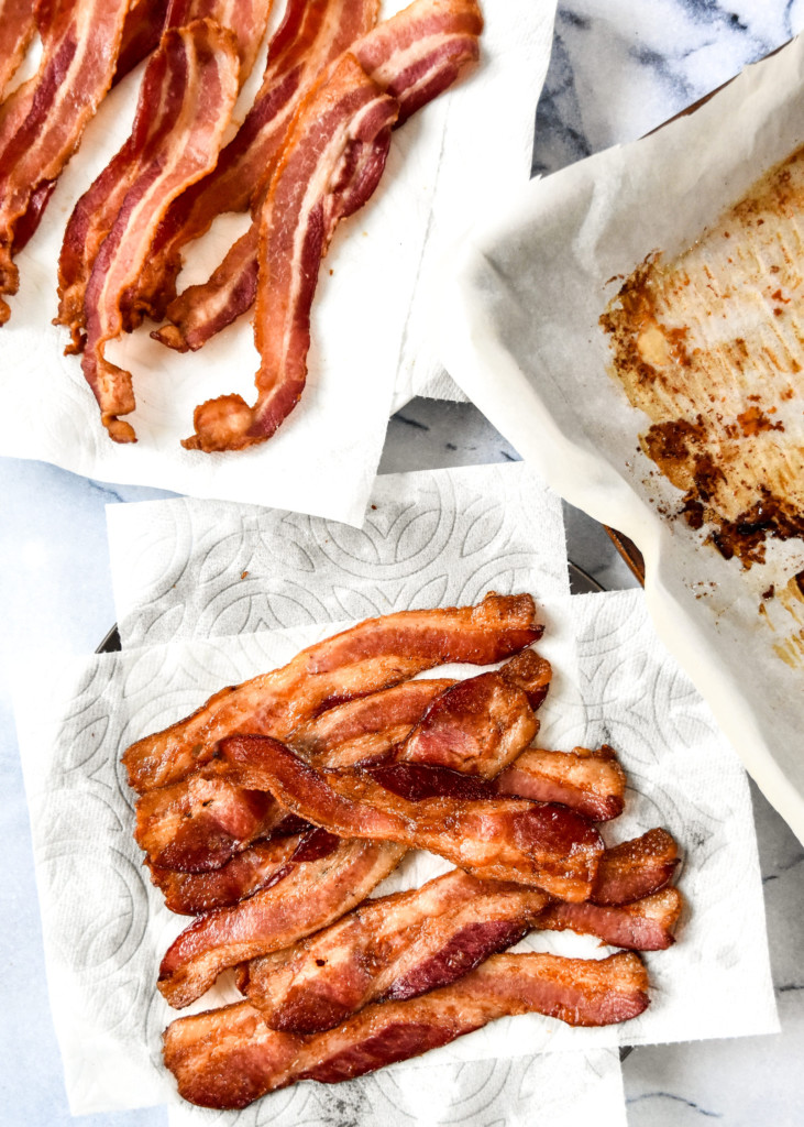 oven cooked bacon on a plate lined with paper towels.