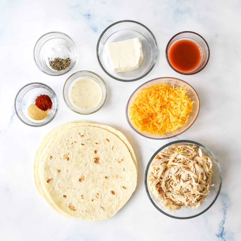 ingredients laid out for the buffalo chicken flautas in individual bowls.