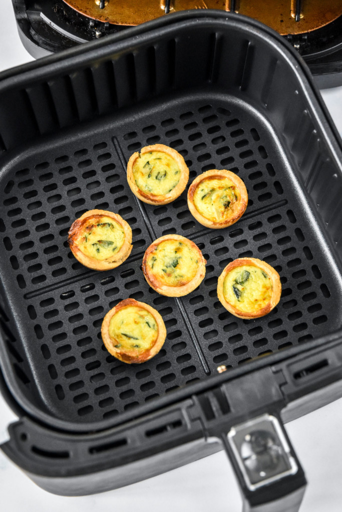 cooked previously frozen mini quiches in an air fryer basket.