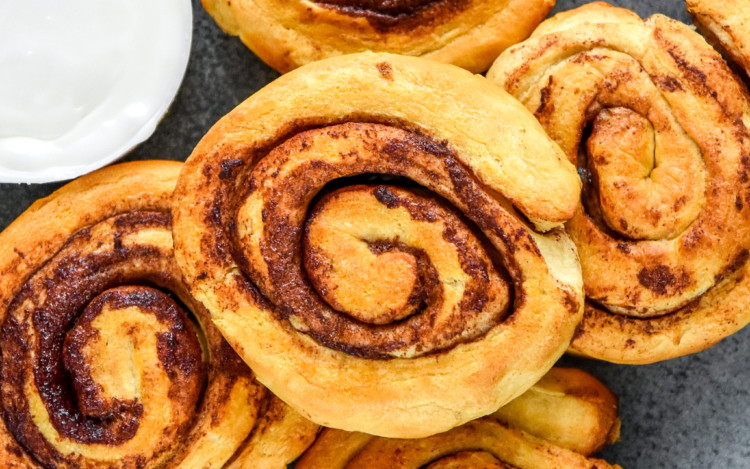 air fryer canned cinnamon rolls cooked on a plate before icing.