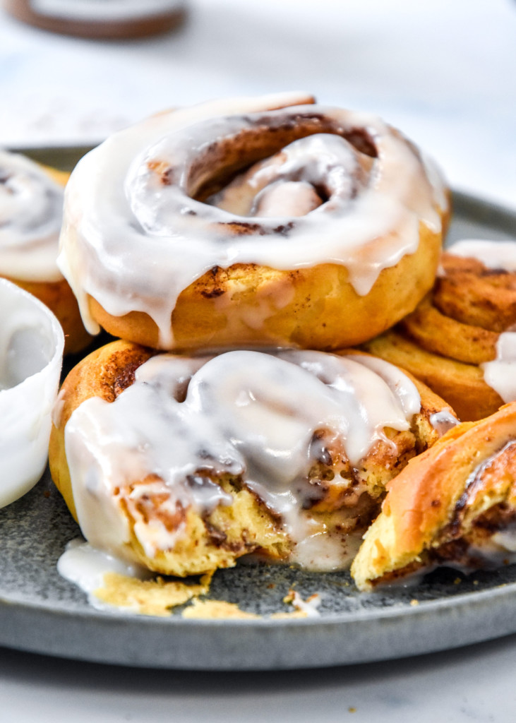air fryer canned cinnamon rolls on a plate cut into with a fork.
