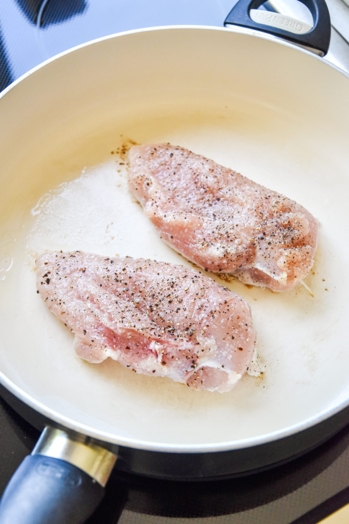 raw chicken in a pan on stovetop.