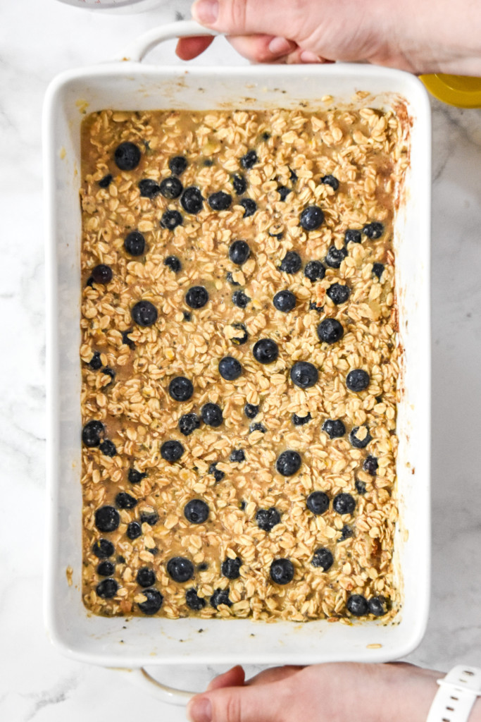 unbaked oatmeal mixture with blueberries in a casserole dish about to go into the oven.