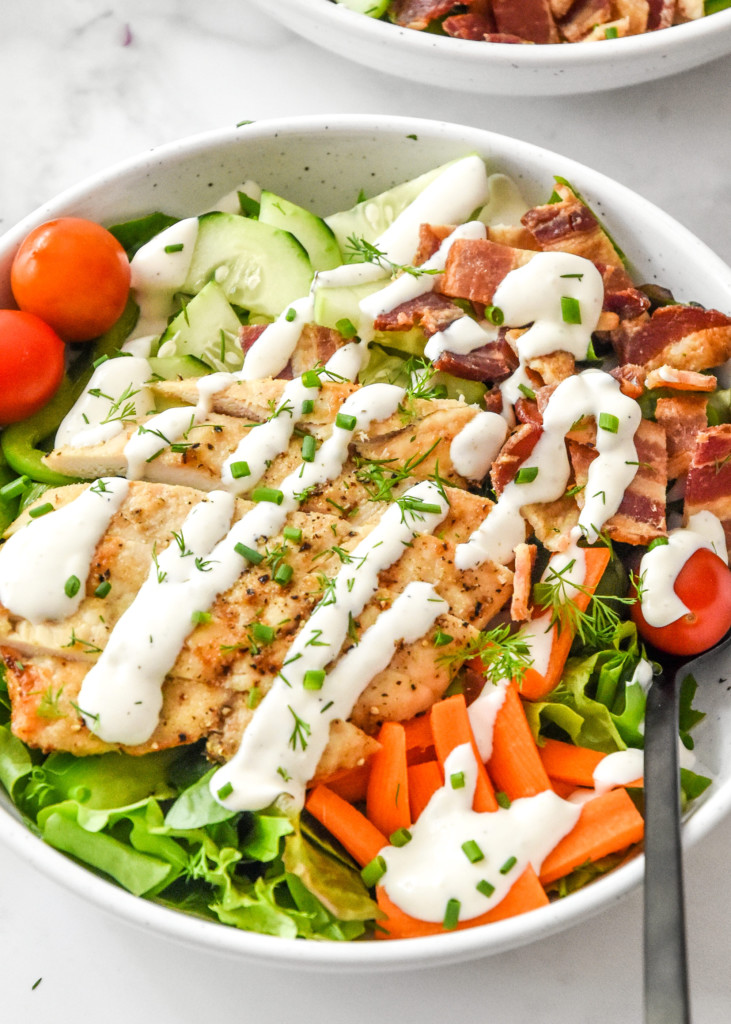 close up of a chicken bacon ranch salad in a bowl with a fork.