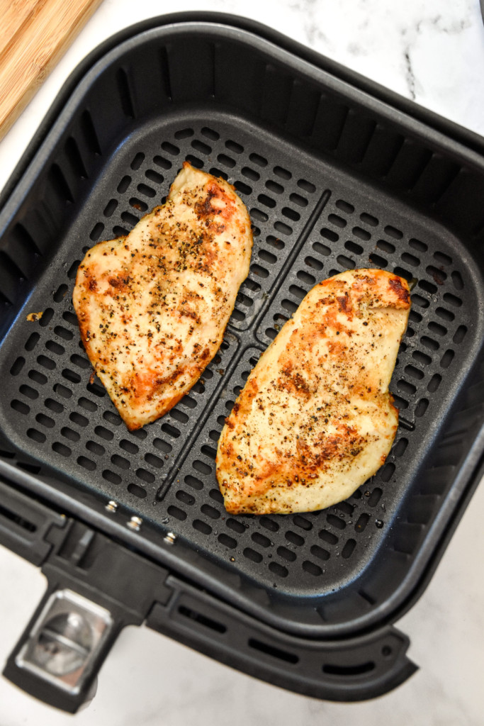 cooked chicken breasts in the air fryer basket for the herby lemon chicken pasta salad.