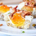 Tater Tot Crust Baked Egg Muffins on a plate cut in half showing the yolk inside.