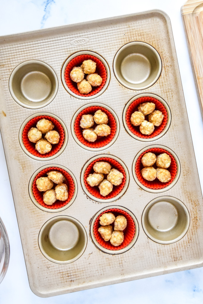 tater tots in a muffin pan before baking.