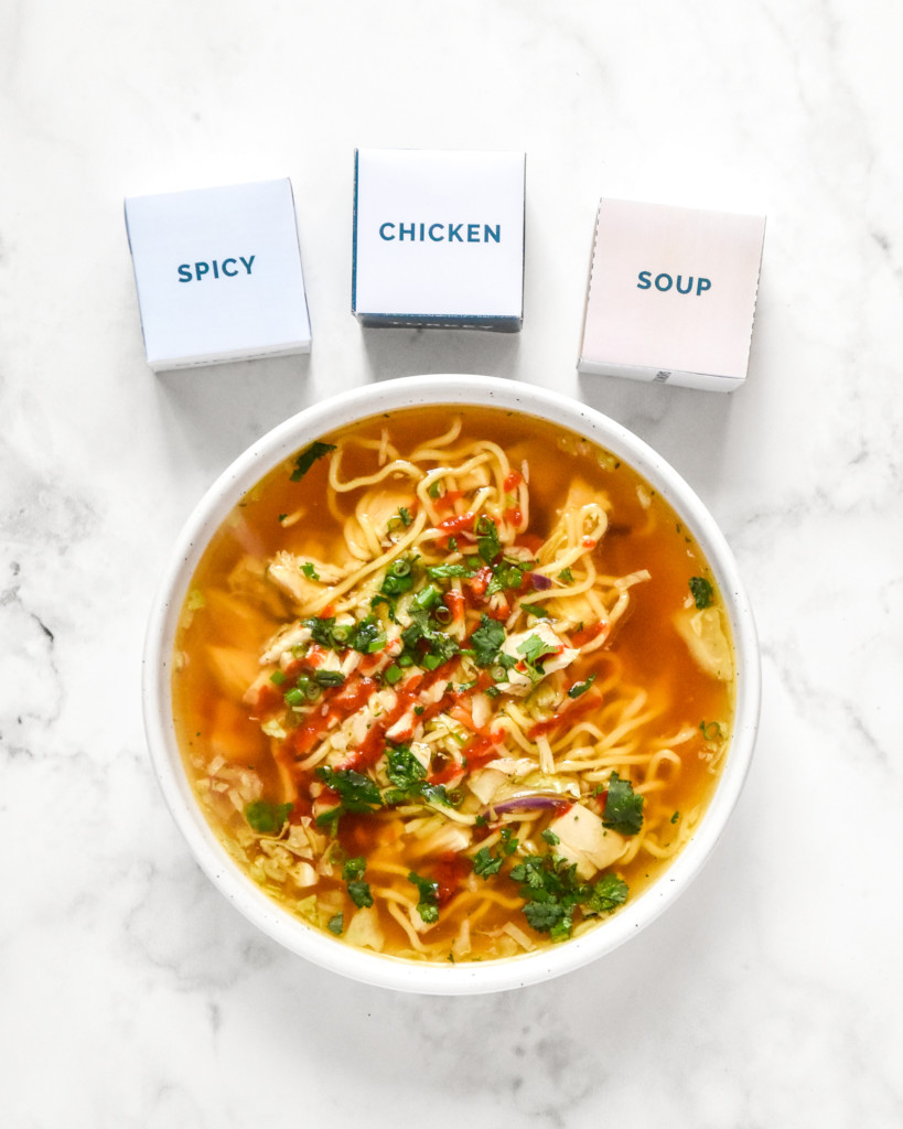 a bowl of spicy chicken soup next to the dinner dice rolled to spicy chicken soup.