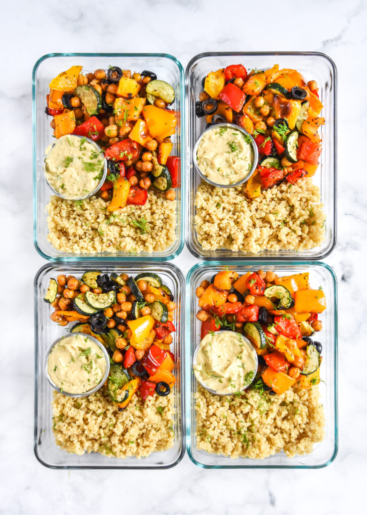 4 glass containers of mediterranean inspired grain bowl meal prep meals.