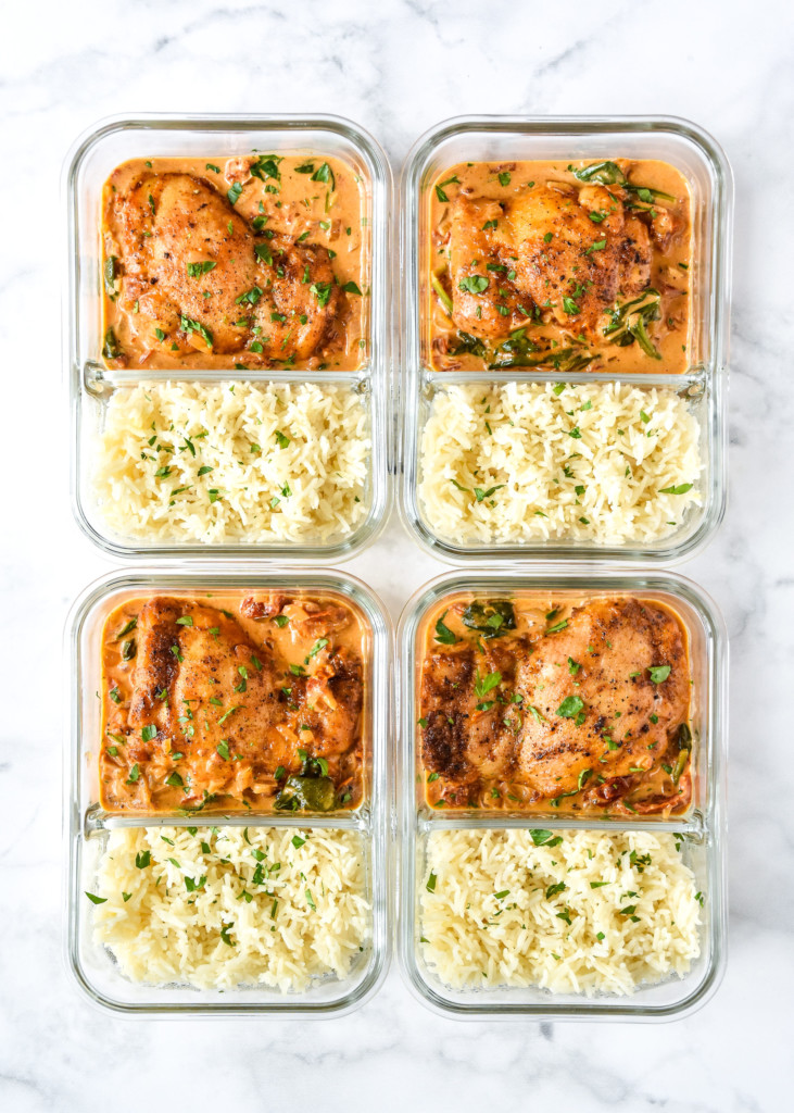 creamy tuscan chicken meal prep with rice portioned into 4 glass meal prep containers.