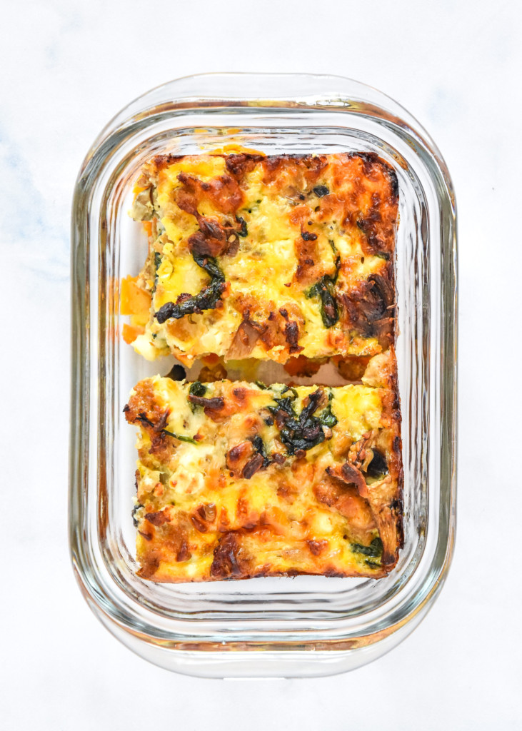 two pieces of breakfast casserole in a glass meal prep container.