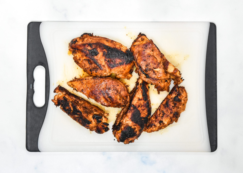 cooked chipotle grilled chicken on a cutting board.