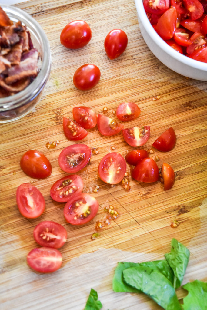cutting up tomatoes on a cutting board.